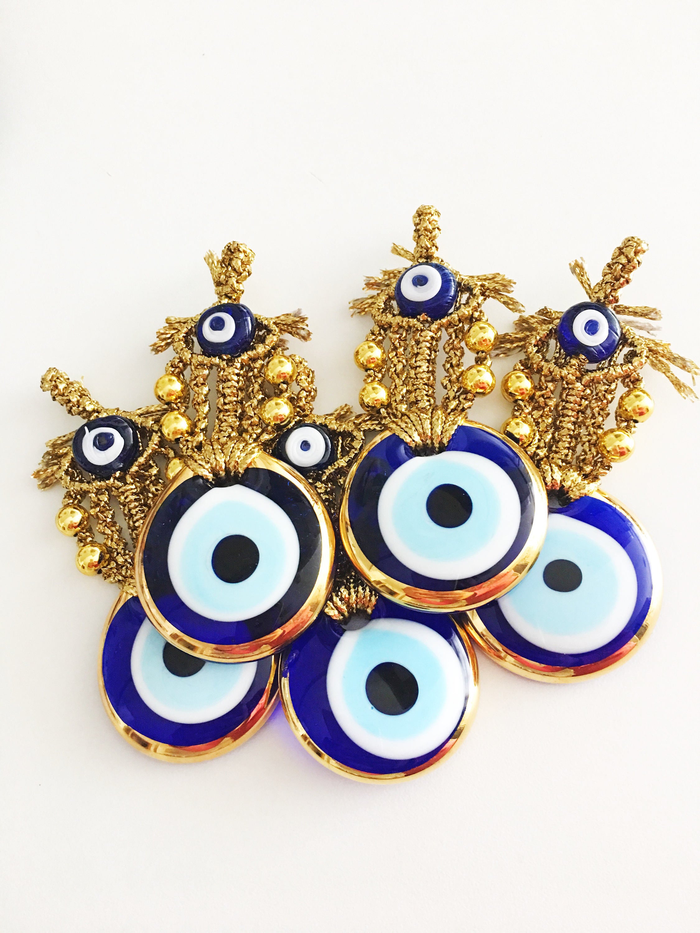 A beautiful Tiny Gold Evil Eye Wall Hanging featuring gold macrame and a large evil eye bead, perfect for home decor or gifting.