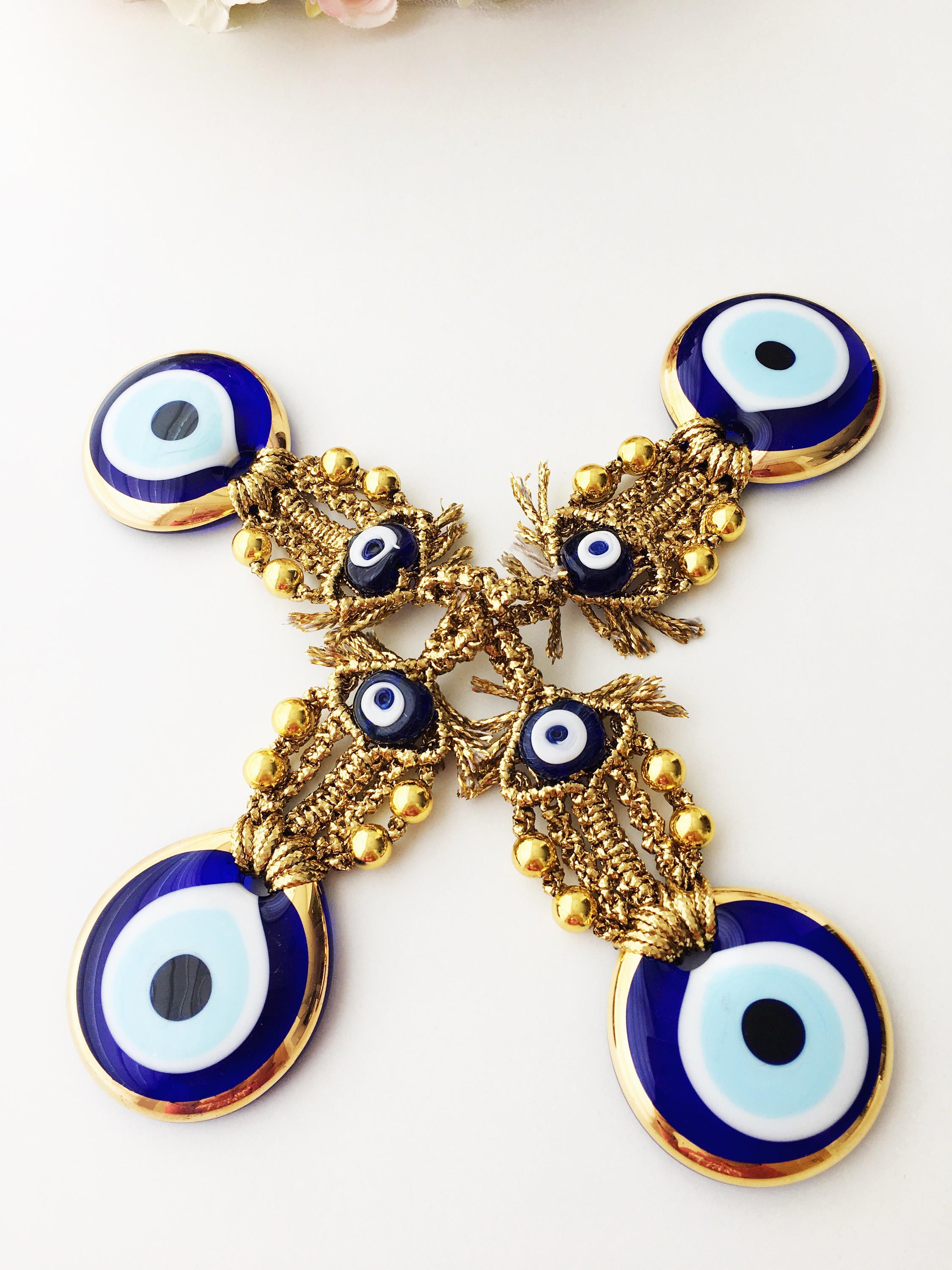 A beautiful Tiny Gold Evil Eye Wall Hanging featuring gold macrame and a large evil eye bead, perfect for home decor or gifting.