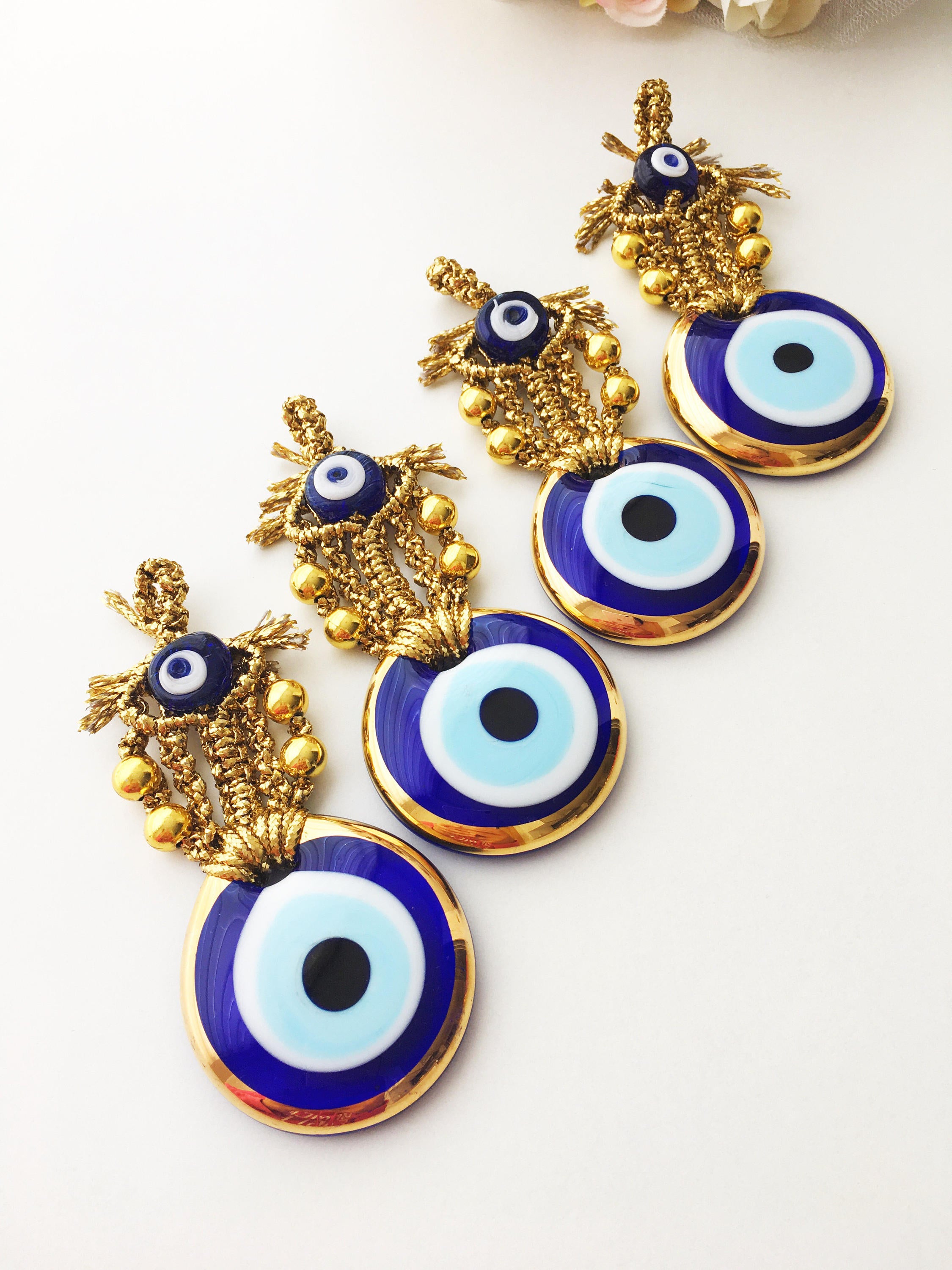 A beautiful Tiny Gold Evil Eye Wall Hanging featuring gold macrame and a large evil eye bead, perfect for home decor or gifting.