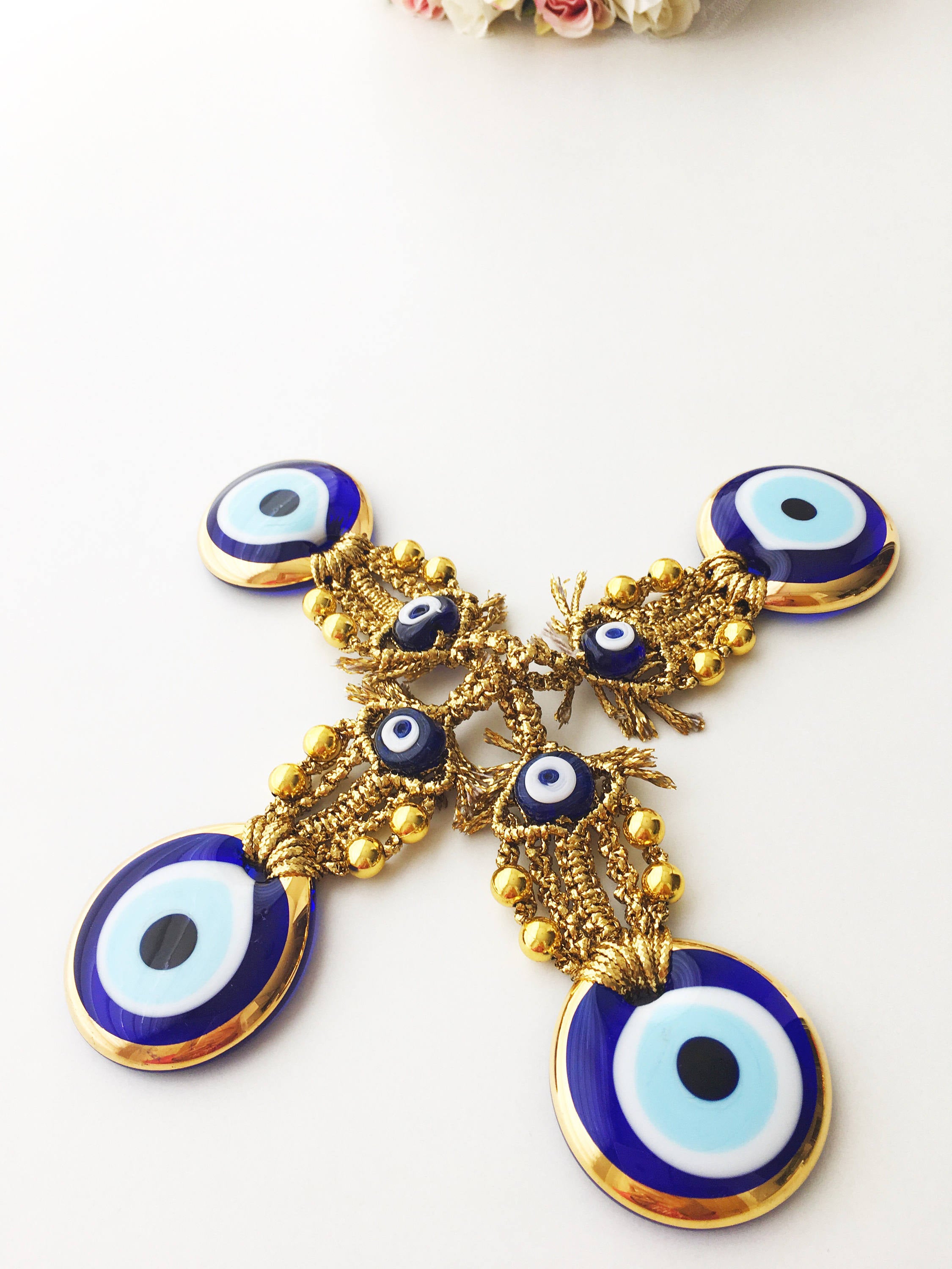 A beautiful Tiny Gold Evil Eye Wall Hanging featuring gold macrame and a large evil eye bead, perfect for home decor or gifting.