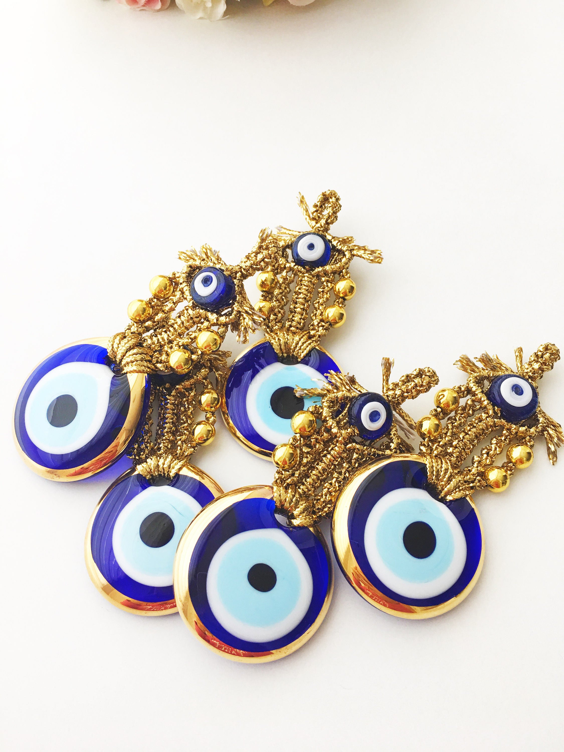 A beautiful Tiny Gold Evil Eye Wall Hanging featuring gold macrame and a large evil eye bead, perfect for home decor or gifting.