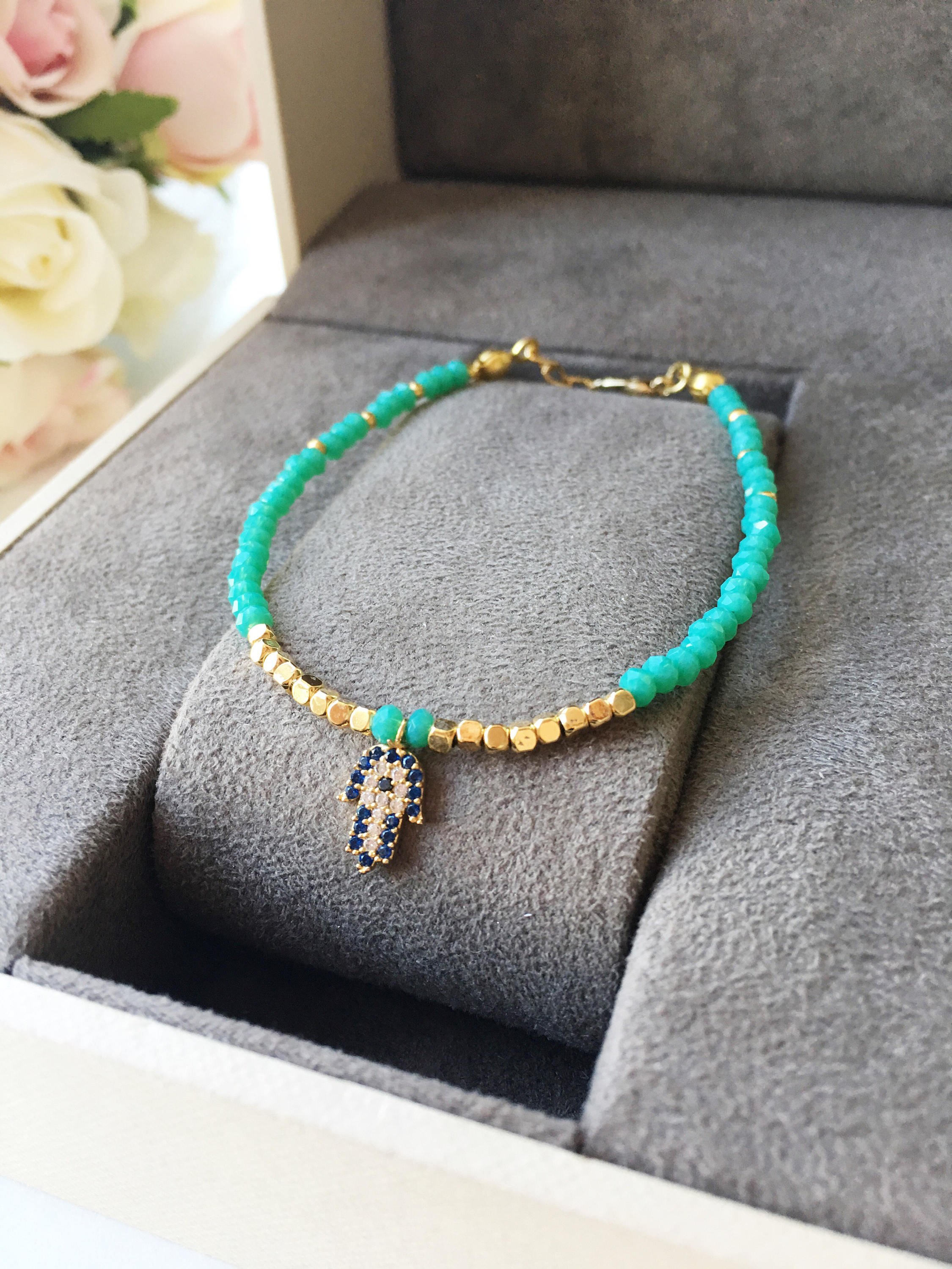 A handmade Tiny Hamsa Charm Bracelet featuring colorful Miyuki seed beads and a zirconia Hamsa charm, symbolizing protection and luck.