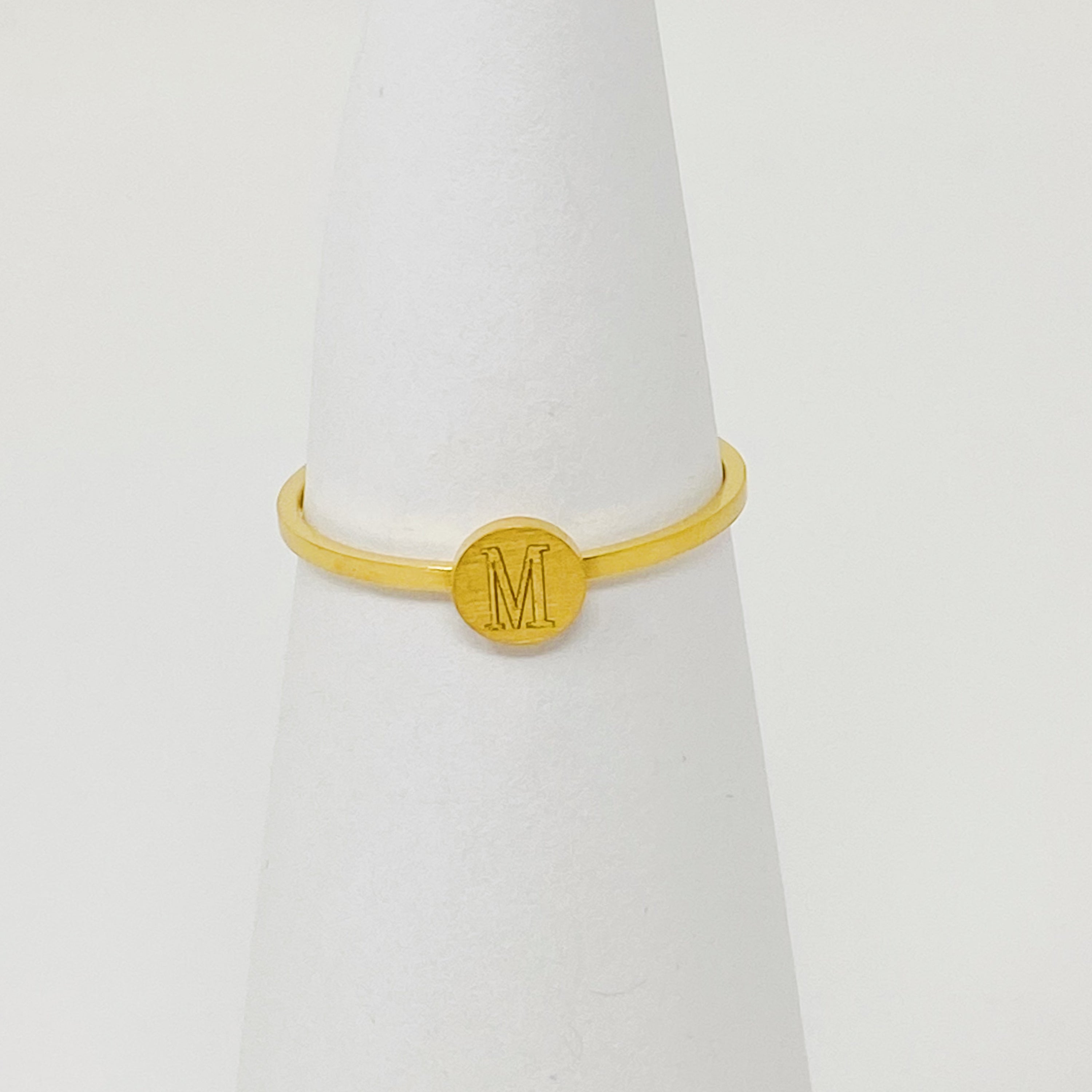 A delicate Tiny Initial Ring featuring a monogrammed initial, crafted from stainless steel with an 18K gold plated finish.