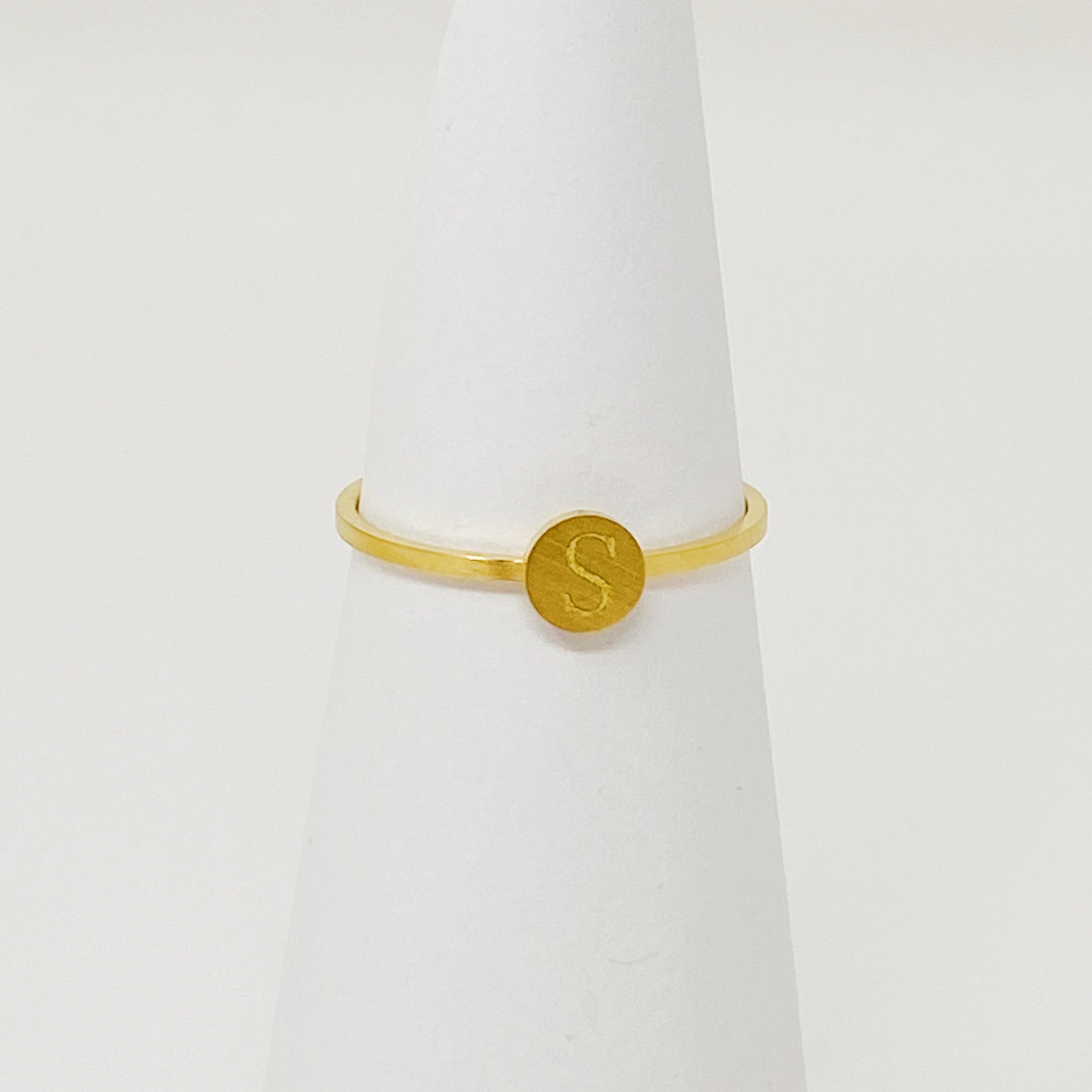 A delicate Tiny Initial Ring featuring a monogrammed initial, crafted from stainless steel with an 18K gold plated finish.