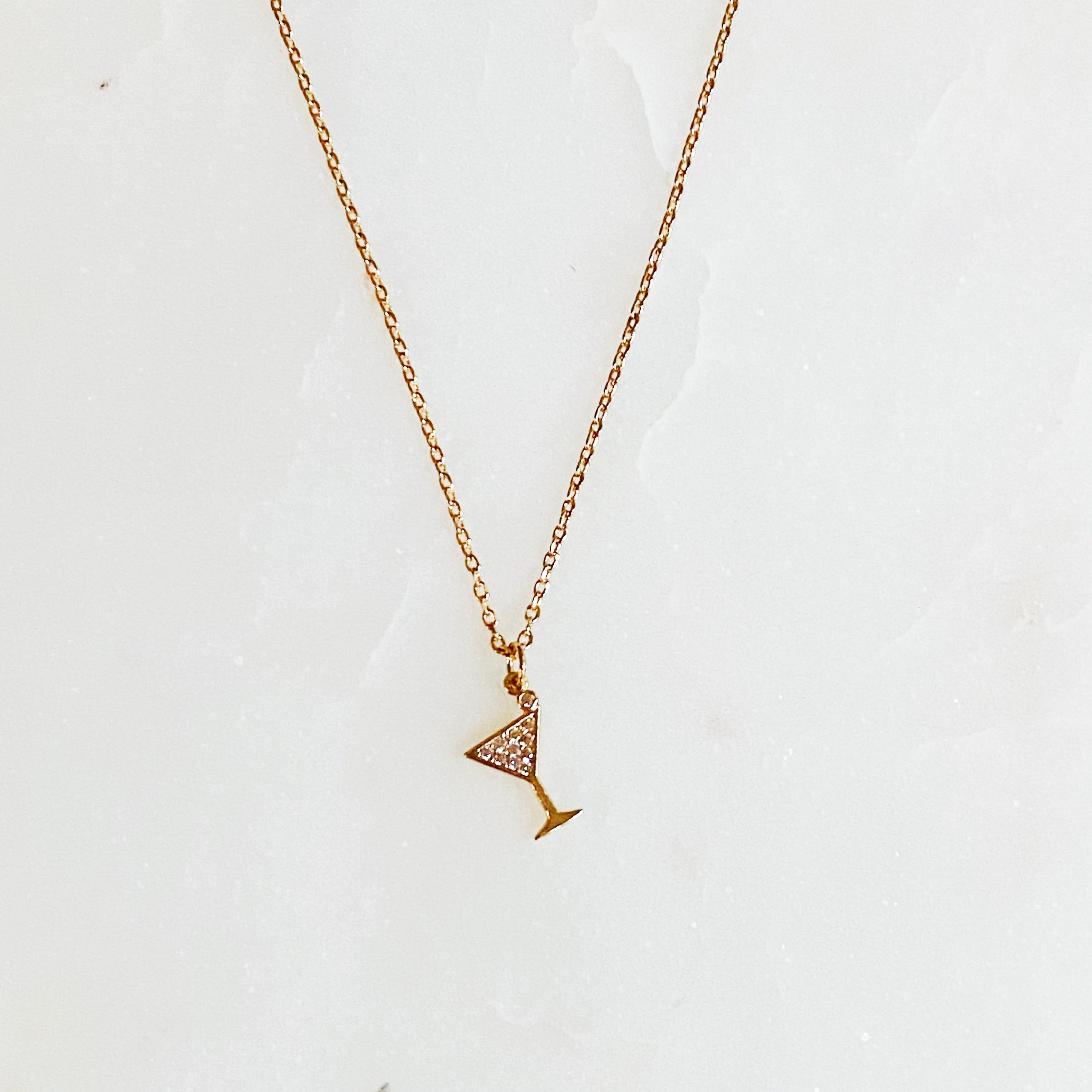 A delicate Tiny Martini Dangle Necklace featuring a gold plated brass chain and a charming martini glass pendant.