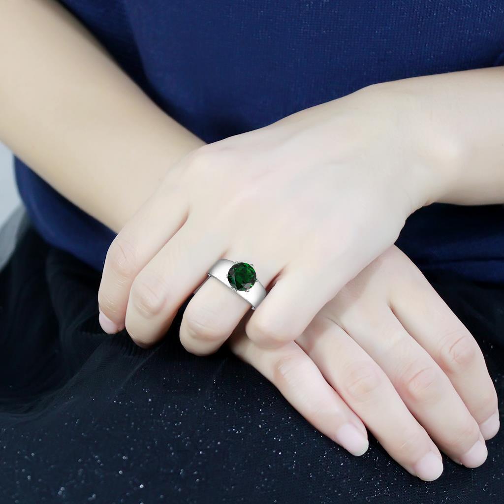 High polished stainless steel ring featuring a synthetic emerald glass stone, showcasing a sleek and elegant design.