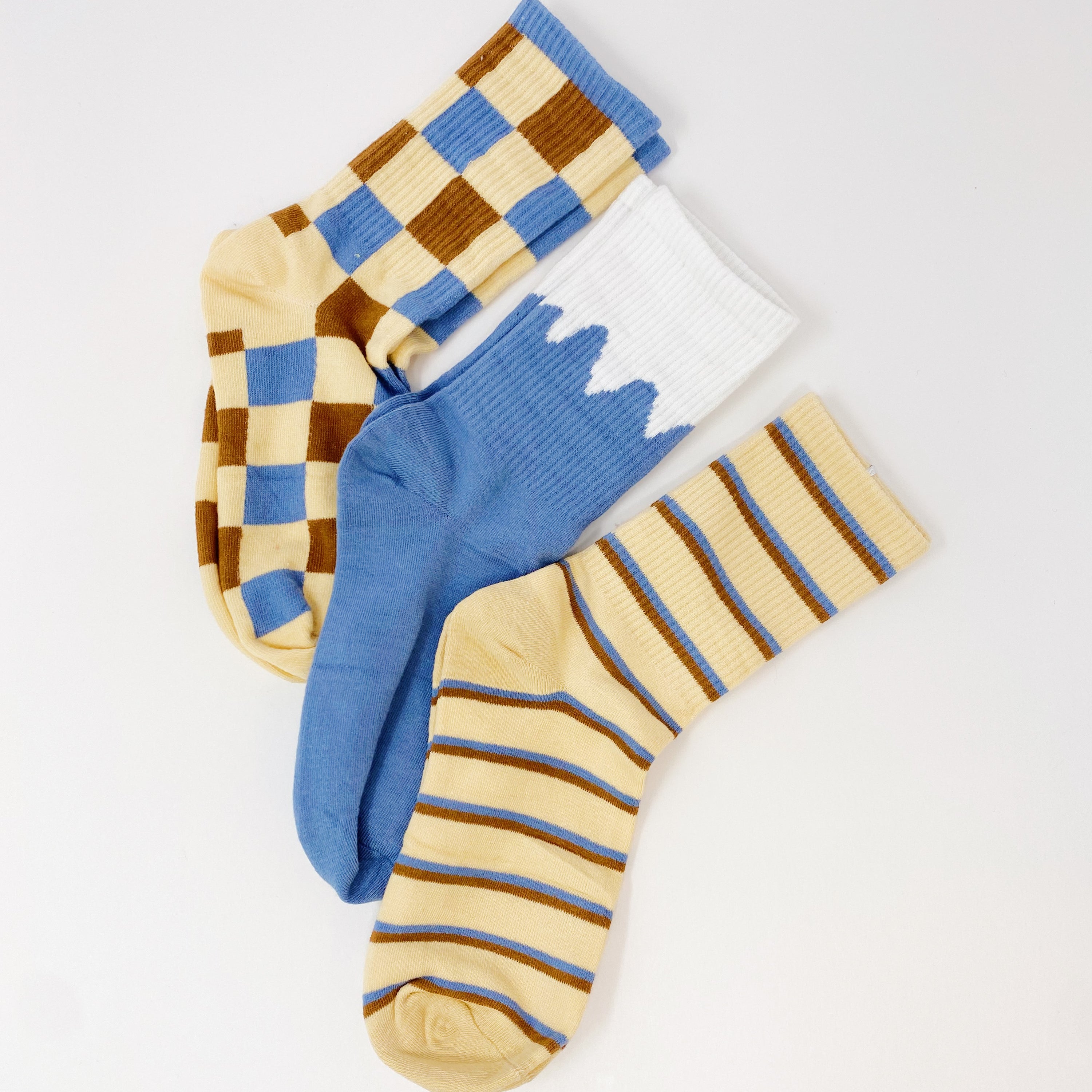 Trendy Pattern Trio Socks Set featuring three stylish pairs in unique designs, packaged in a clear cello bag.