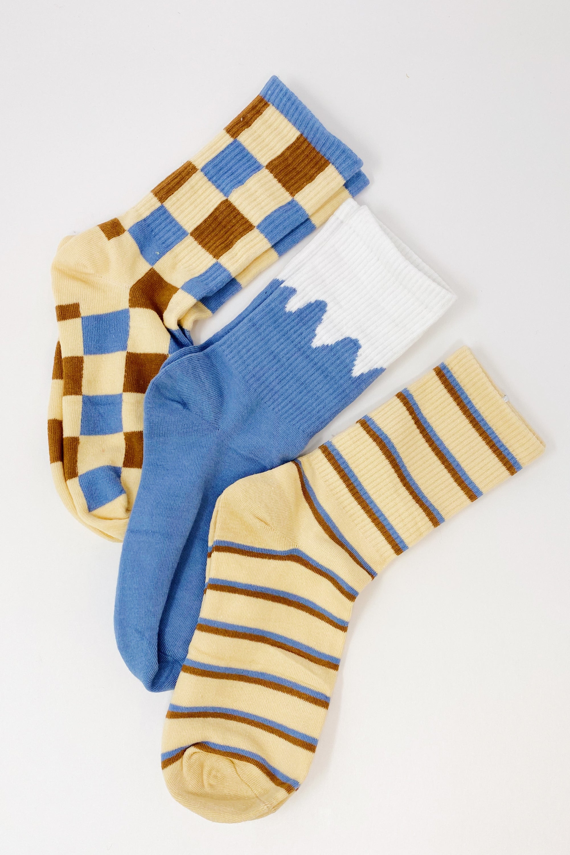 Trendy Pattern Trio Socks Set featuring three stylish pairs in unique designs, packaged in a clear cello bag.