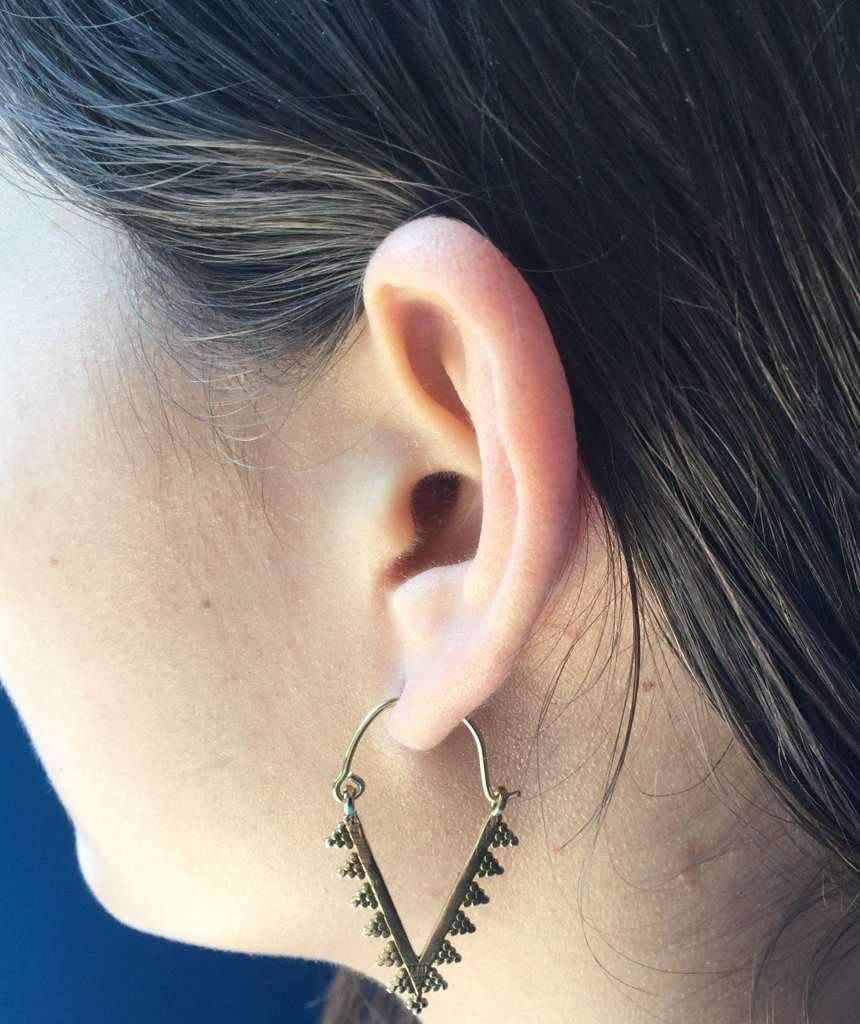 A pair of modern triangle earrings in silver and gold, showcasing a unique design suitable for various occasions.