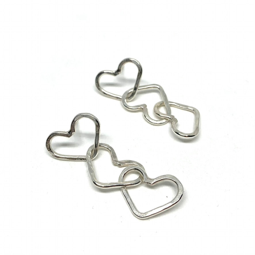 Handcrafted Triple Heart Dangle Earrings made from recycled metals, showcasing a unique design with three hearts hanging elegantly.