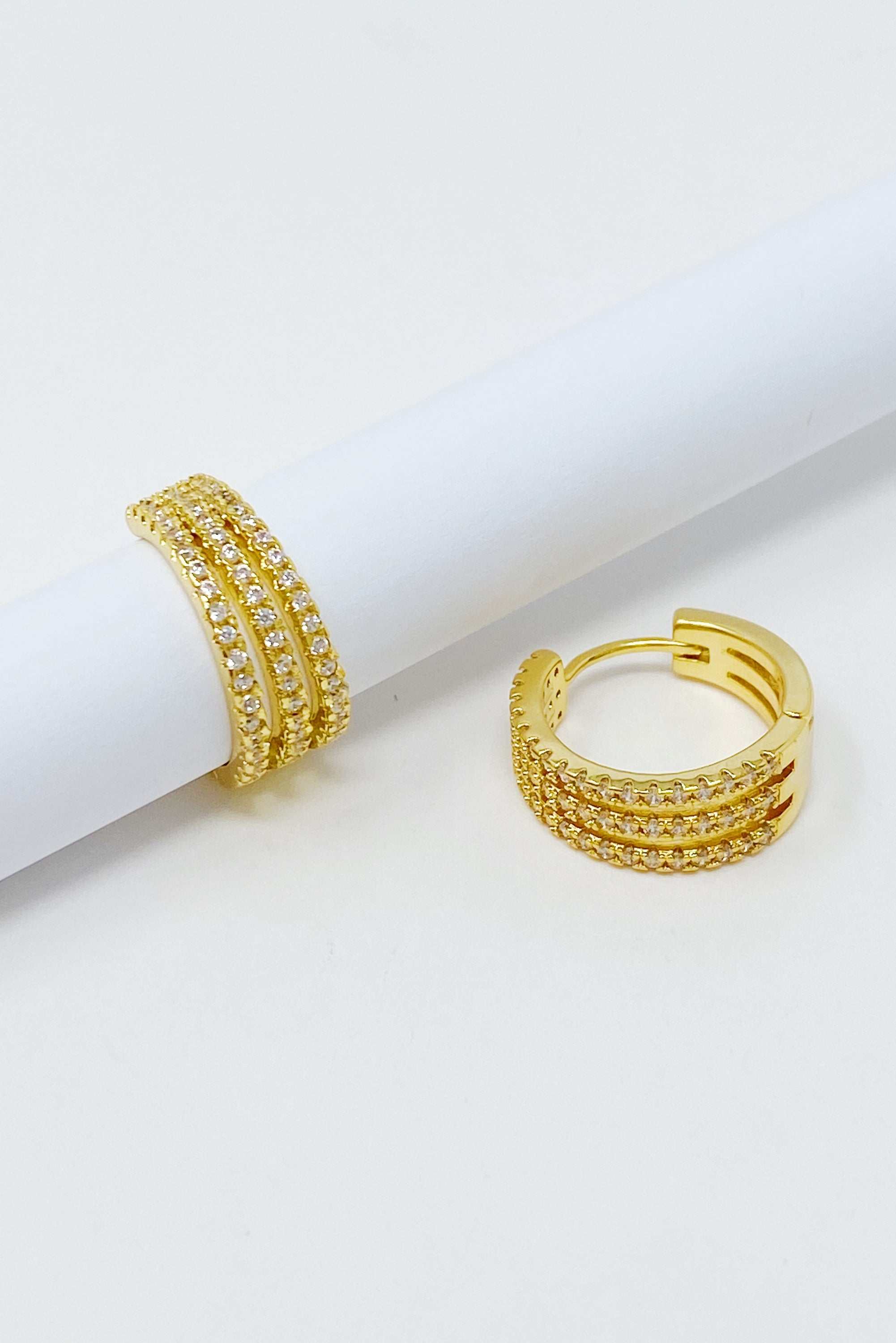 Elegant Triple Shine Huggie Earrings featuring cubic zirconia and gold plated brass, perfect for any occasion.