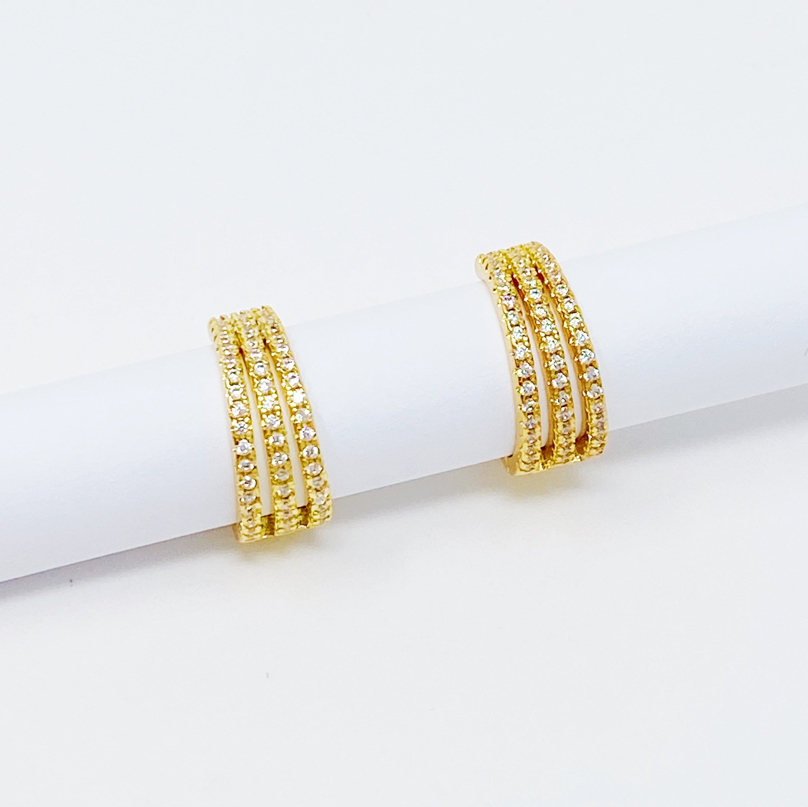 Elegant Triple Shine Huggie Earrings featuring cubic zirconia and gold plated brass, perfect for any occasion.