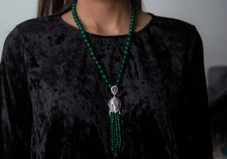 TULIP Emerald Necklace featuring a floral tassel design in yellow gold plated brass, showcasing intricate details and natural stones.