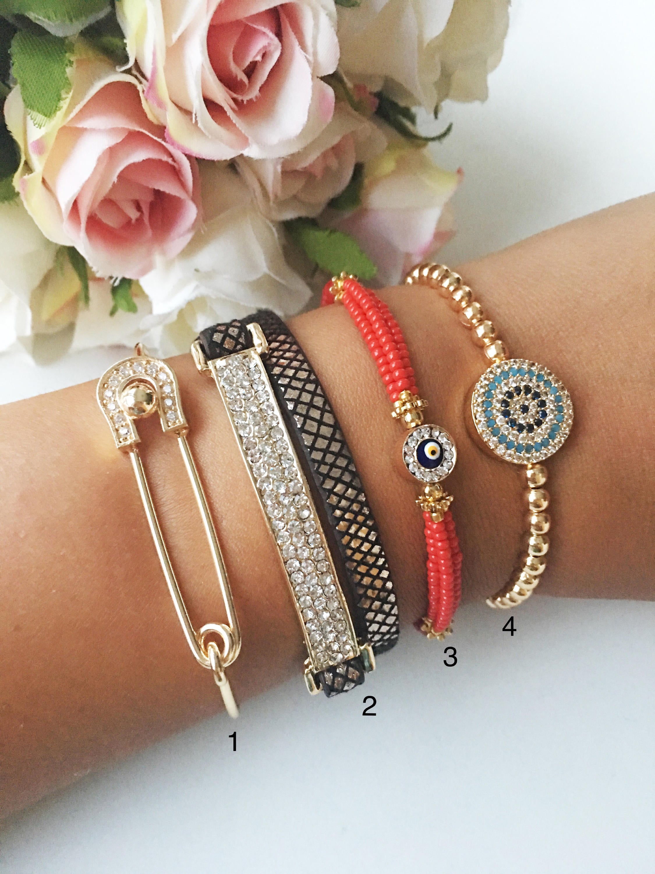 A beautiful set of handmade Turkish evil eye bracelets featuring gold bangles, Miyuki beads, and zirconia leather, showcasing unique designs.