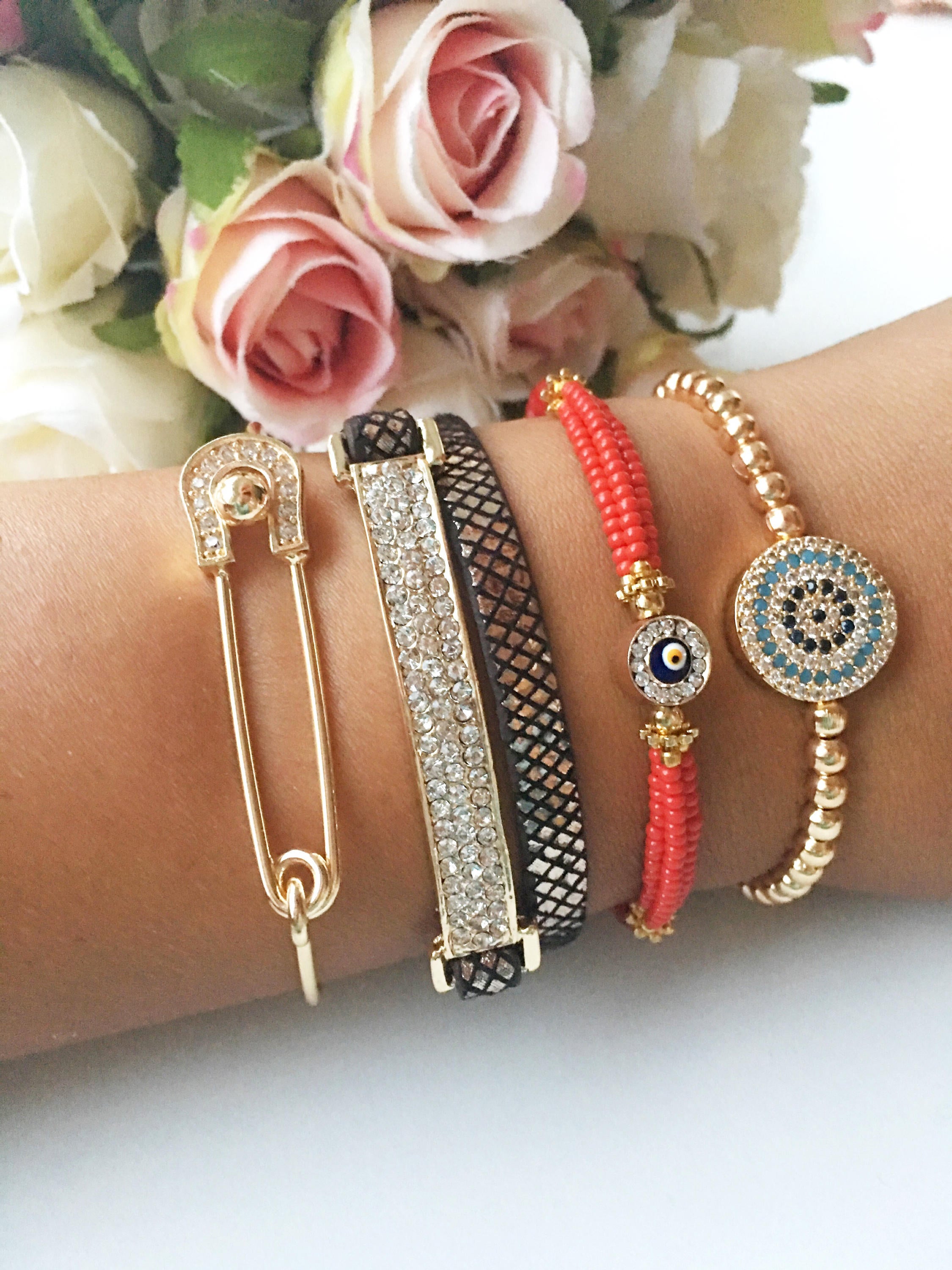 A beautiful set of handmade Turkish evil eye bracelets featuring gold bangles, Miyuki beads, and zirconia leather, showcasing unique designs.