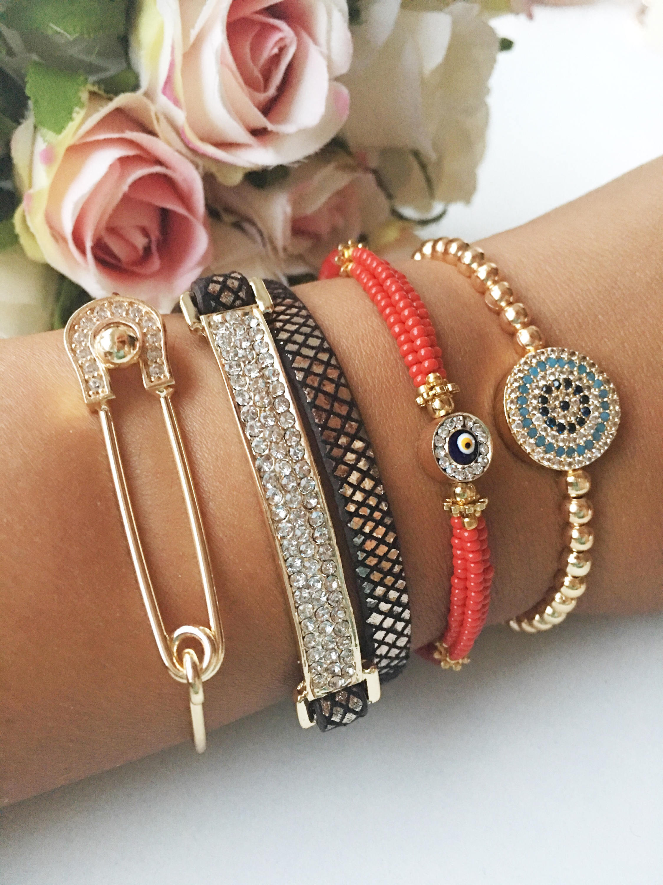 A beautiful set of handmade Turkish evil eye bracelets featuring gold bangles, Miyuki beads, and zirconia leather, showcasing unique designs.