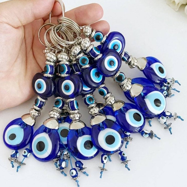 A beautiful Turkish Evil Eye Keychain featuring a blue glass evil eye bead and an oval white bead, symbolizing protection and good luck.