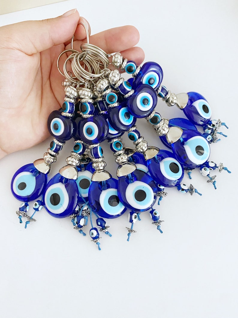 A beautiful Turkish Evil Eye Keychain featuring a blue glass evil eye bead and an oval white bead, symbolizing protection and good luck.