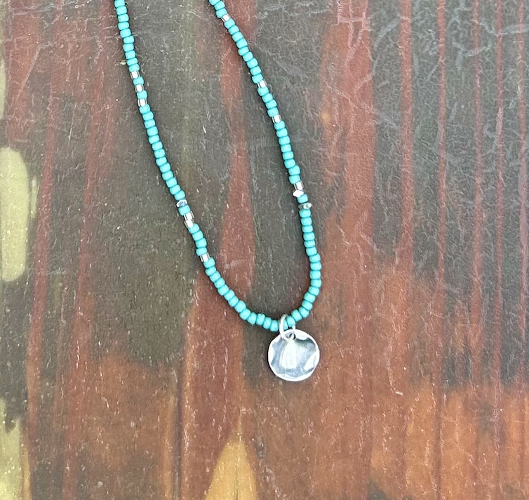 Turquoise Boho Seed Bead Necklace featuring a hammered silver circle pendant, showcasing vibrant beads and elegant design.