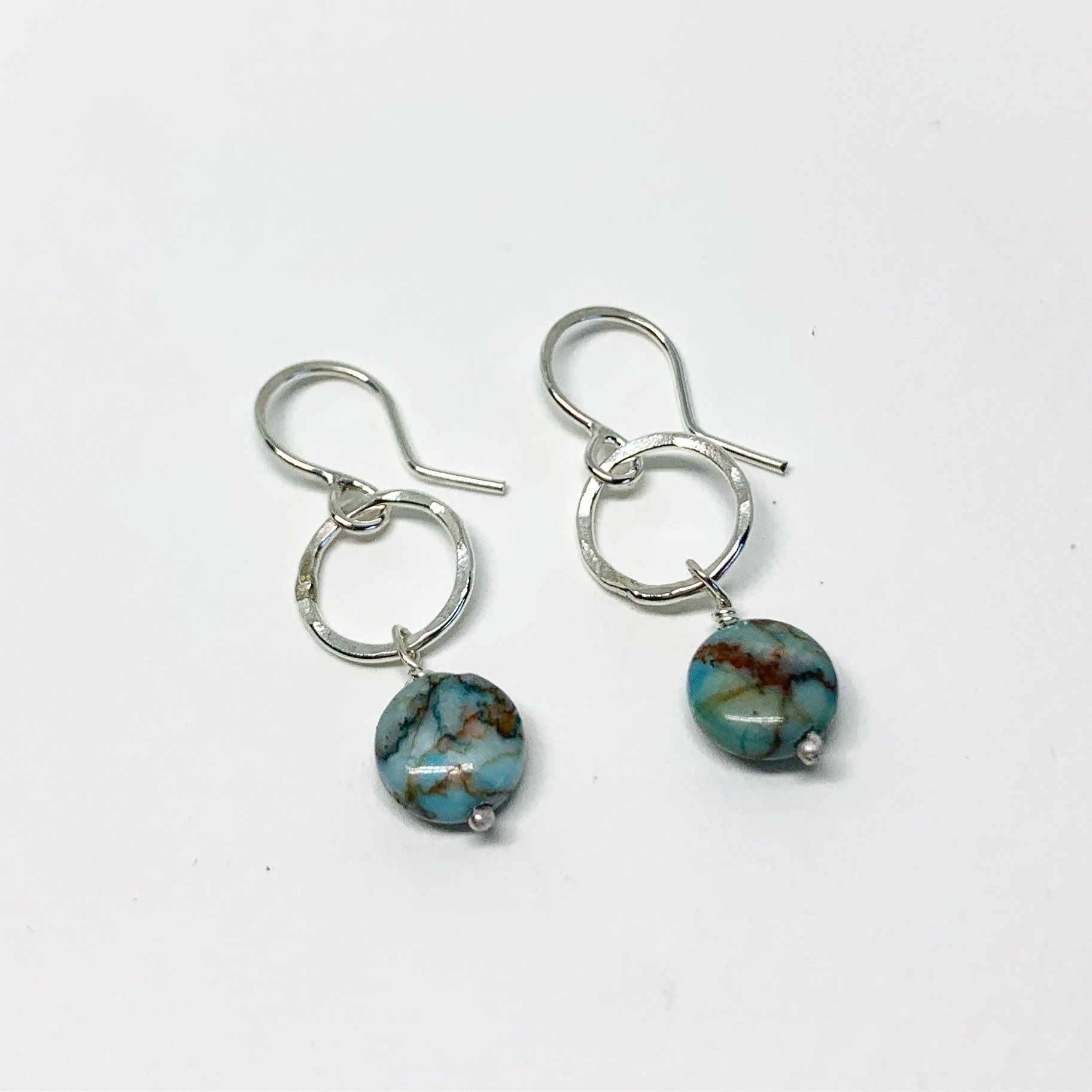 A pair of handmade turquoise disc drop earrings featuring 8mm blue turquoise round discs, hanging from a hammered circle in sterling silver or yellow gold fill.