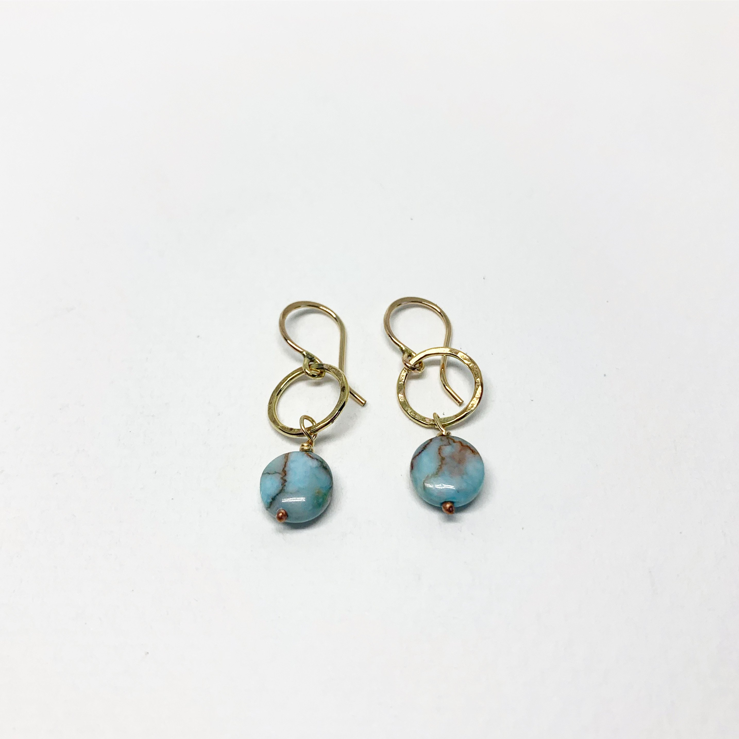 A pair of handmade turquoise disc drop earrings featuring 8mm blue turquoise round discs, hanging from a hammered circle in sterling silver or yellow gold fill.