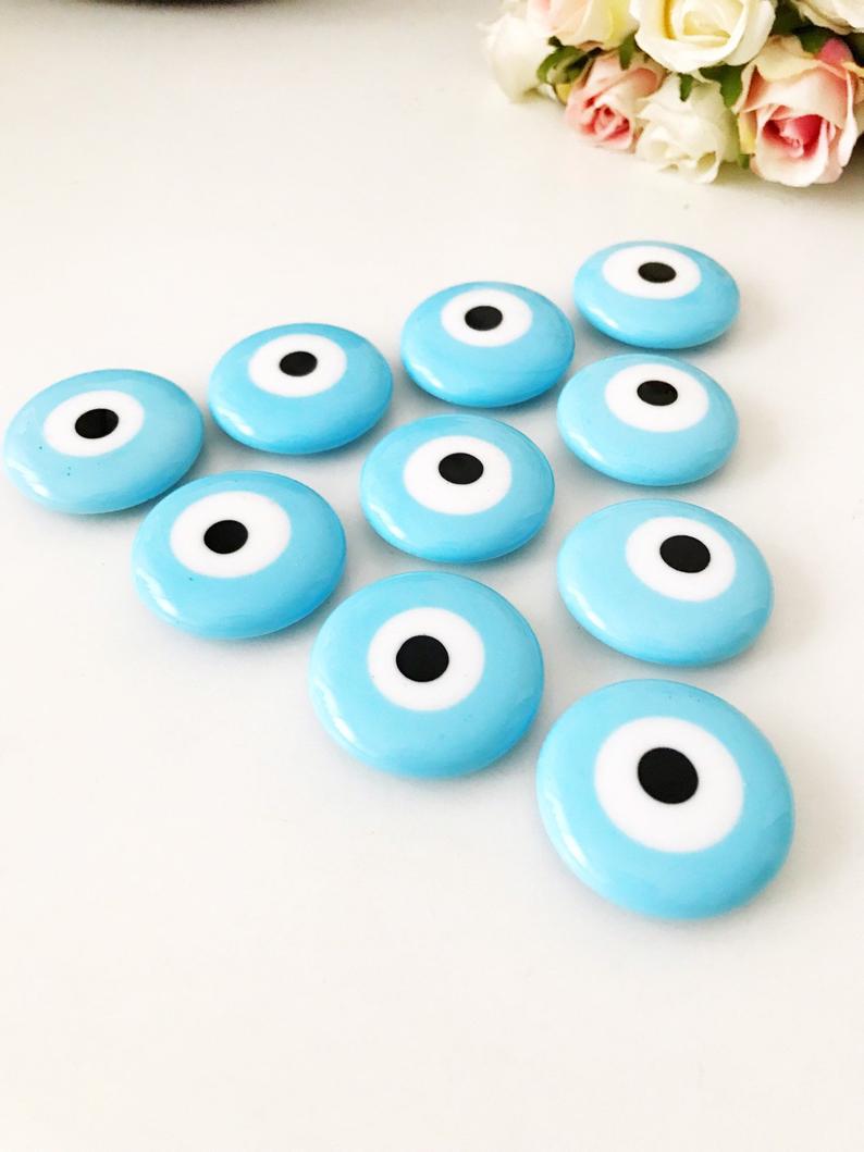 Turquoise handmade glass evil eye bead magnet, featuring a vibrant turquoise color and intricate design, perfect for home or office decor.