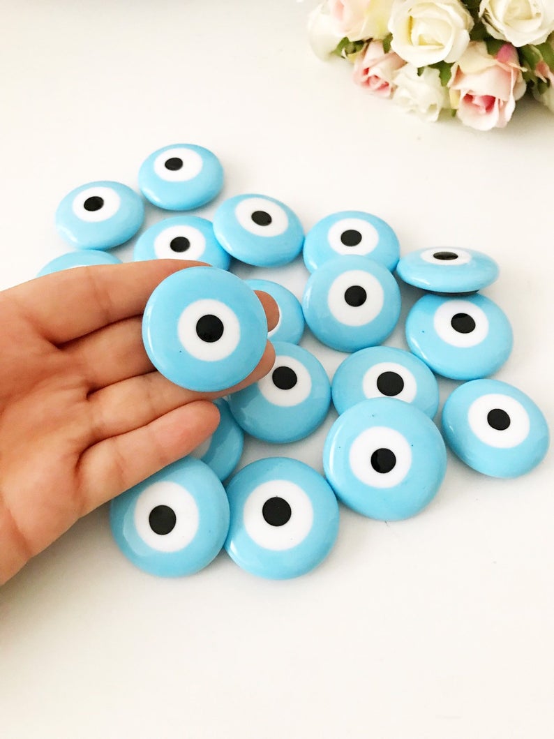 Turquoise handmade glass evil eye bead magnet, featuring a vibrant turquoise color and intricate design, perfect for home or office decor.