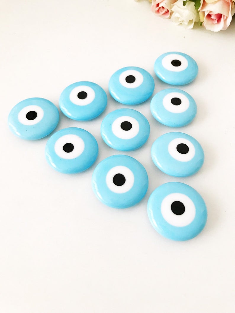 Turquoise handmade glass evil eye bead magnet, featuring a vibrant turquoise color and intricate design, perfect for home or office decor.