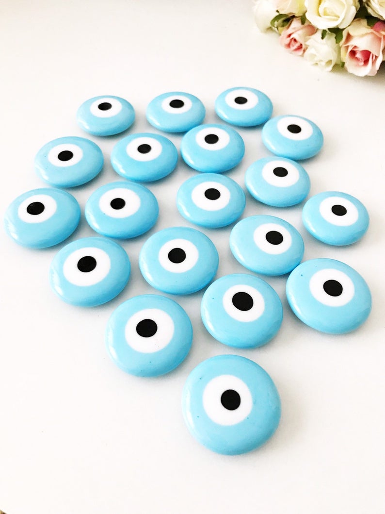 Turquoise handmade glass evil eye bead magnet, featuring a vibrant turquoise color and intricate design, perfect for home or office decor.