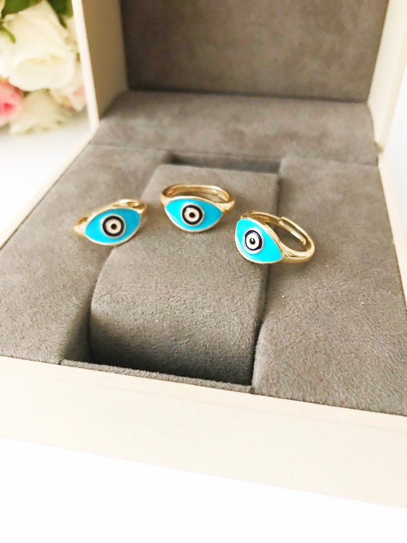 Turquoise Oval Evil Eye Ring featuring an adjustable gold band and a vibrant turquoise evil eye bead, symbolizing protection and elegance.