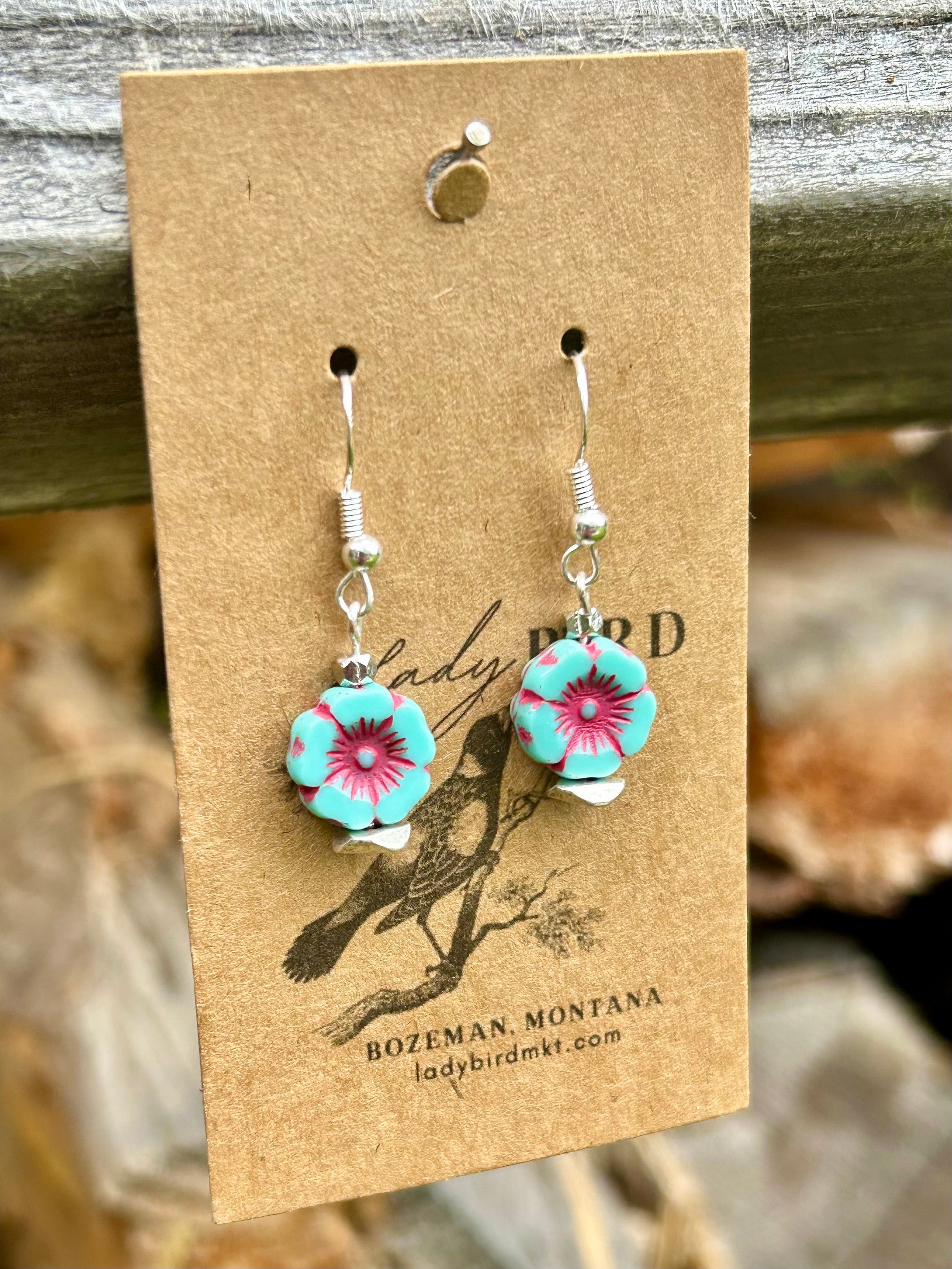 Turquoise and red etched glass hibiscus flower earrings, showcasing vibrant colors and intricate design.