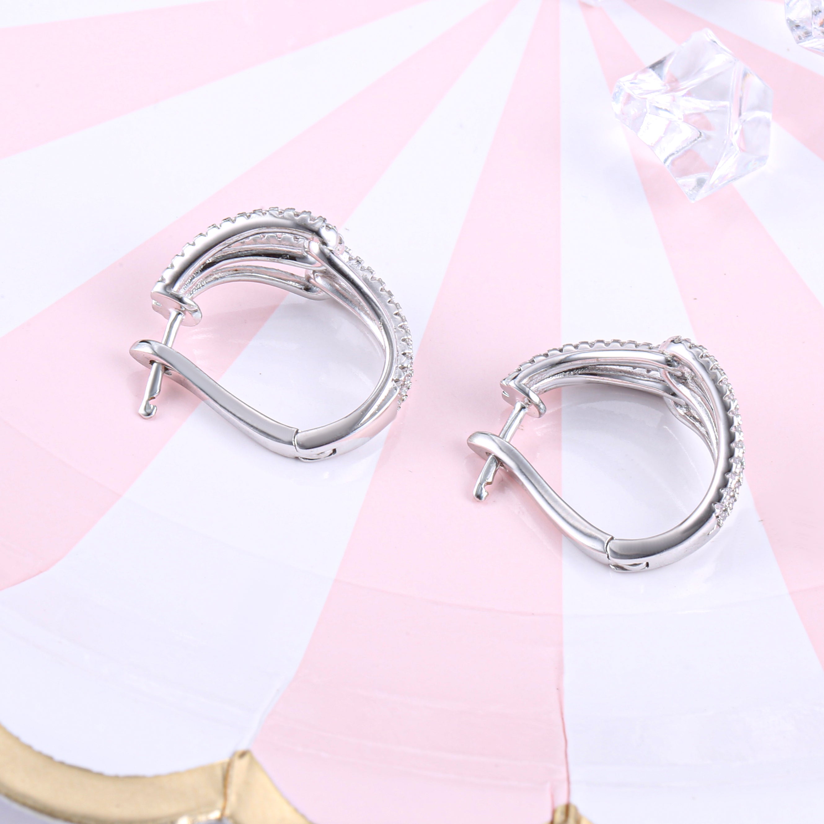 Twist huggie earring made of 925 sterling silver with white sapphire, showcasing a modern design and luxurious finish.