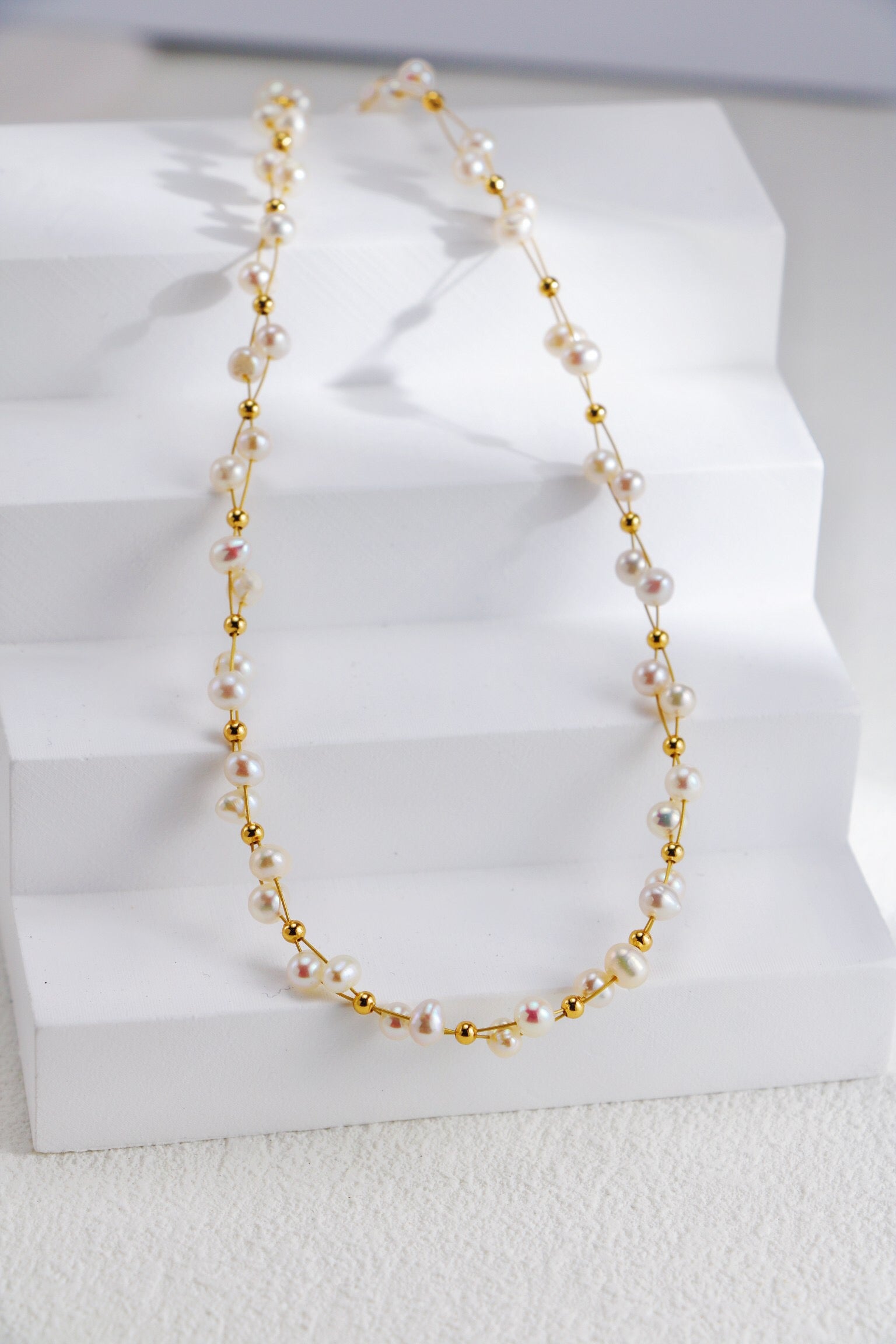 A beautifully handcrafted Twisted Freshwater Pearl Beads Necklace featuring natural pearls and gold vermeil plating, elegantly displayed on a soft background.