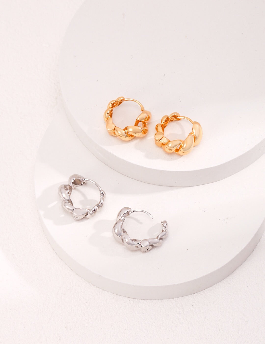 A pair of elegant Twisted Twist Hoops Earrings made from gold vermeil, showcasing a unique twisted design.