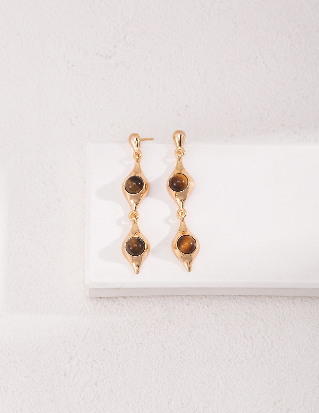 Gold drop earrings with gemstones.