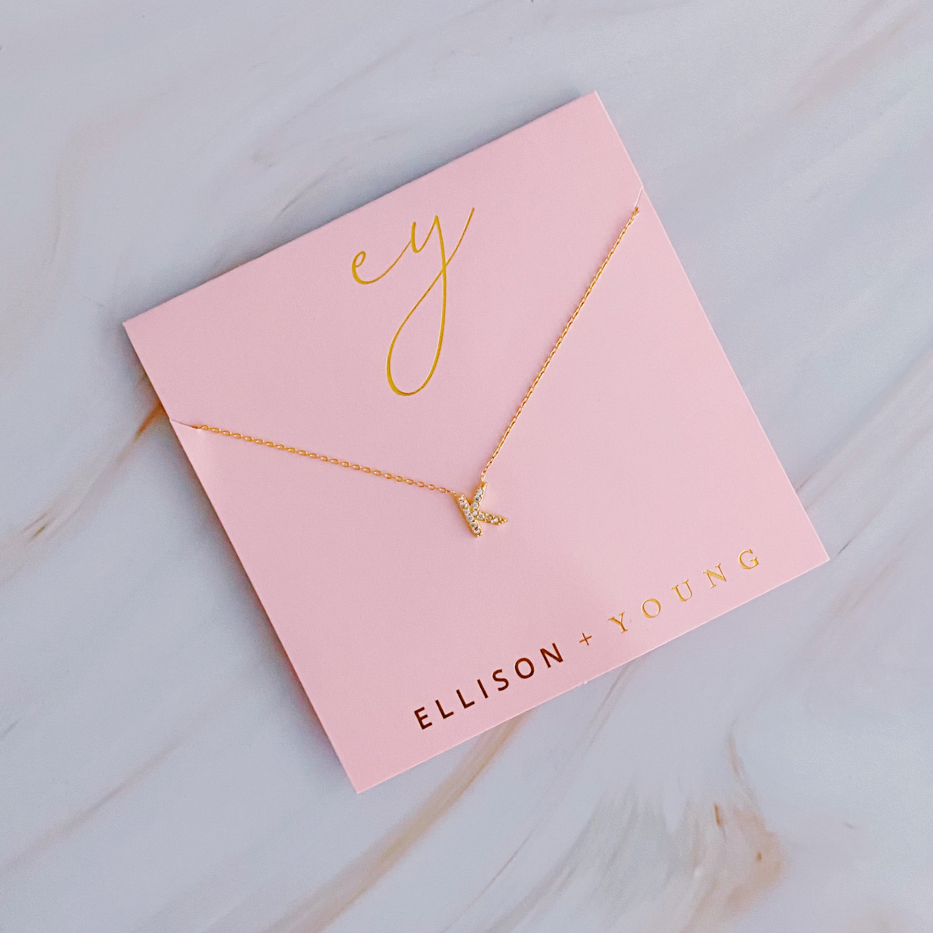 A delicate Understated Beauty Initial Necklace featuring a gold plated initial pendant adorned with sparkling cubic zirconia stones.