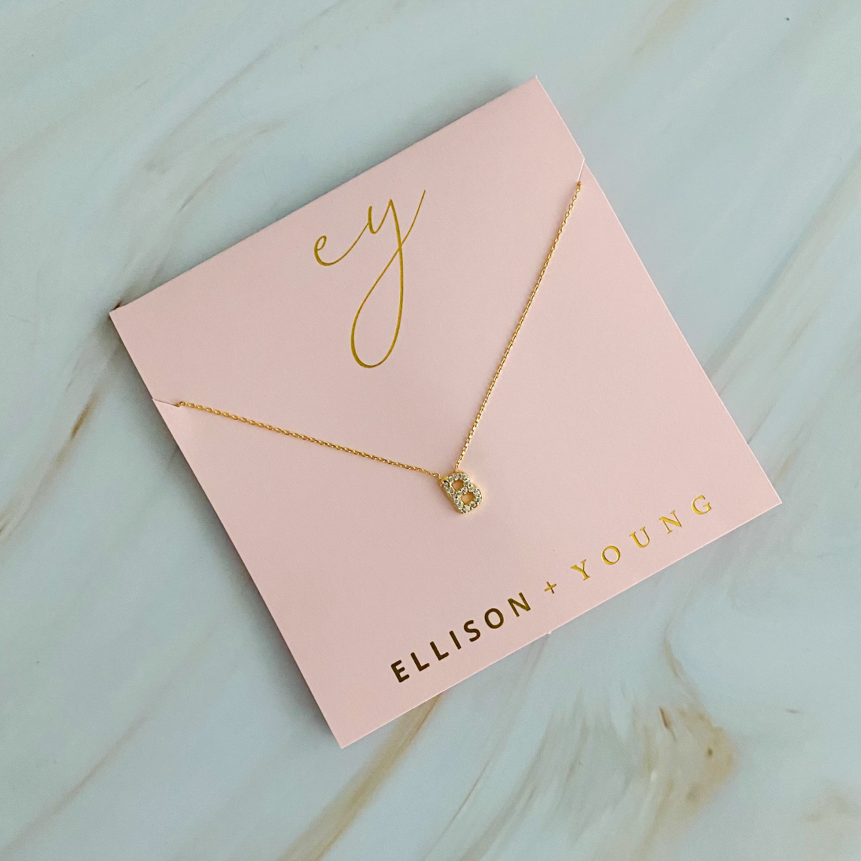 A delicate Understated Beauty Initial Necklace featuring a gold plated initial pendant adorned with sparkling cubic zirconia stones.