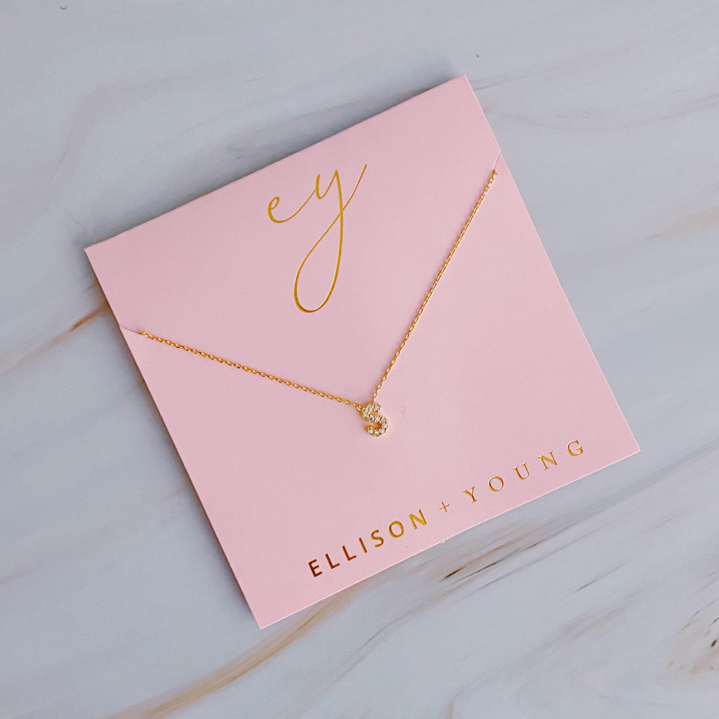 A delicate Understated Beauty Initial Necklace featuring a gold plated initial pendant adorned with sparkling cubic zirconia stones.