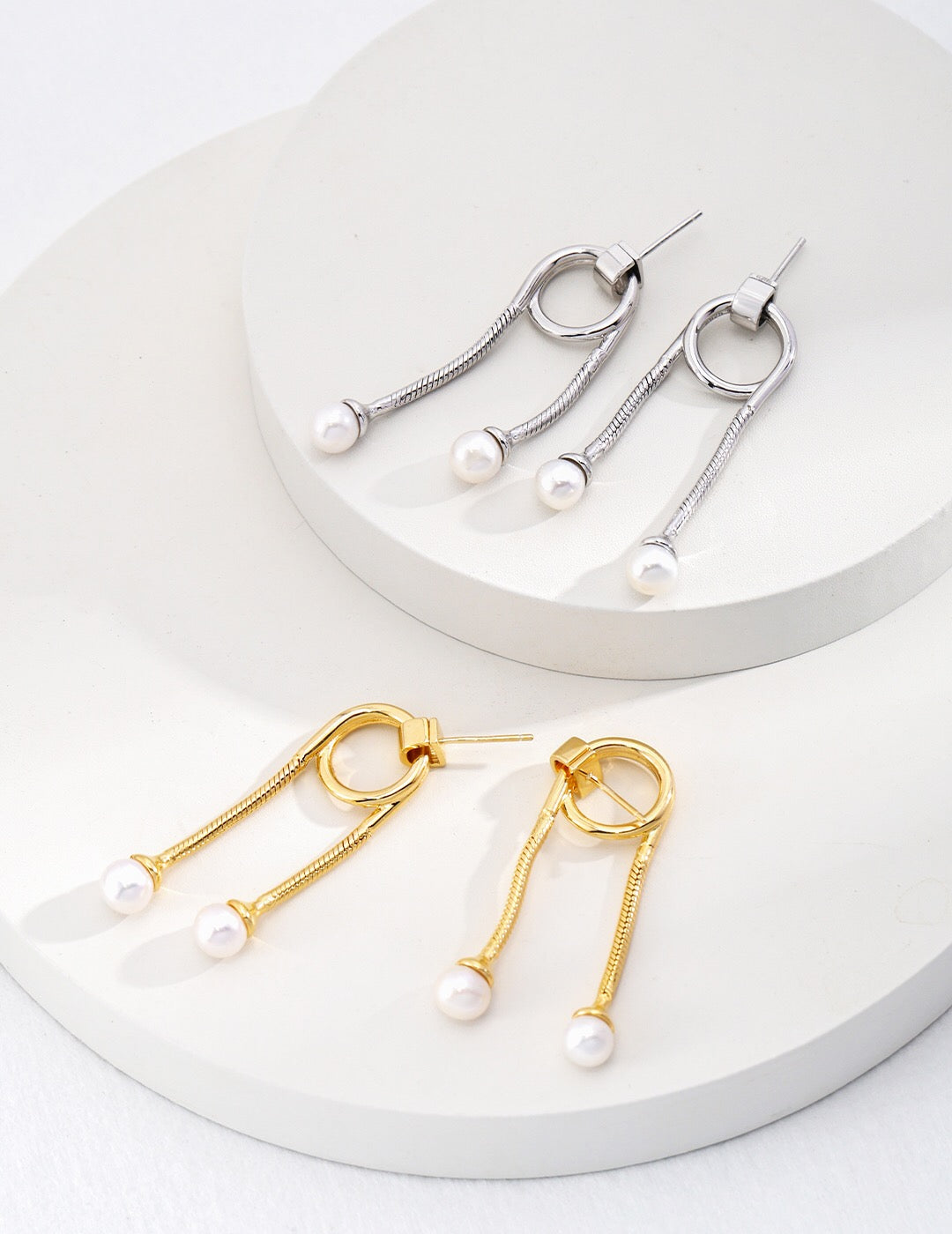 A pair of Unique Style Two Pearls Earrings featuring genuine freshwater pearls set in sterling silver with gold vermeil accents, elegantly displayed.