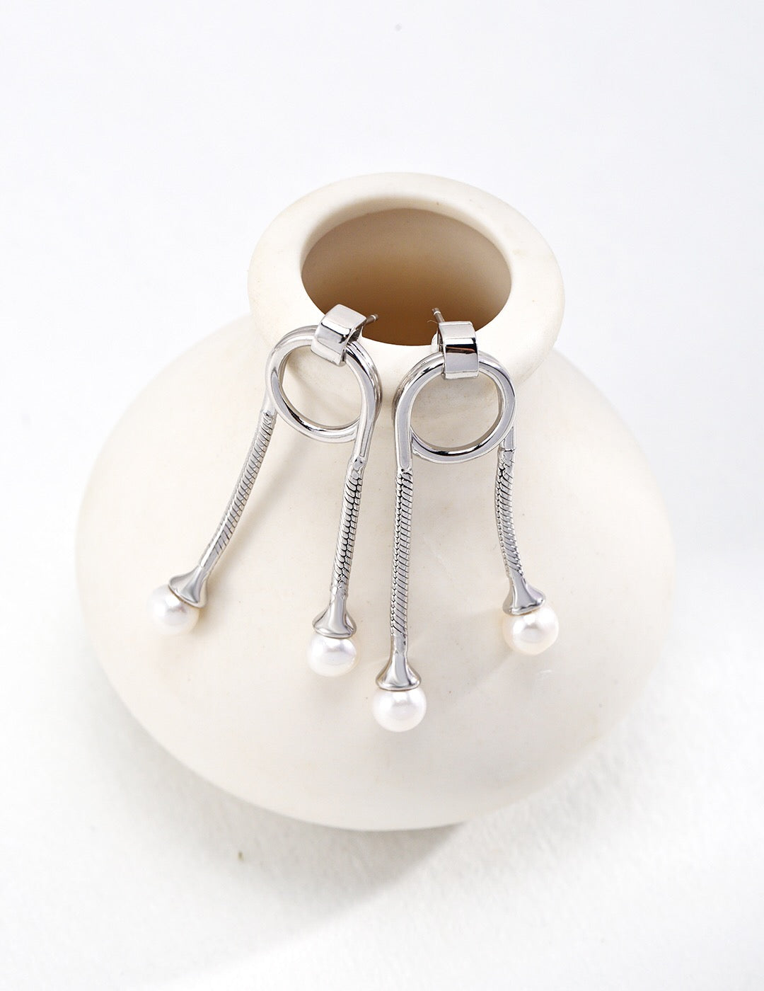 A pair of Unique Style Two Pearls Earrings featuring genuine freshwater pearls set in sterling silver with gold vermeil accents, elegantly displayed.