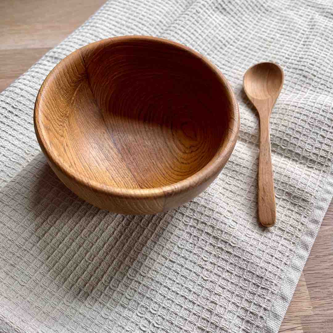 A beautifully handcrafted upcycled wooden spoon made from reclaimed teak wood, showcasing unique grain patterns and a polished finish.