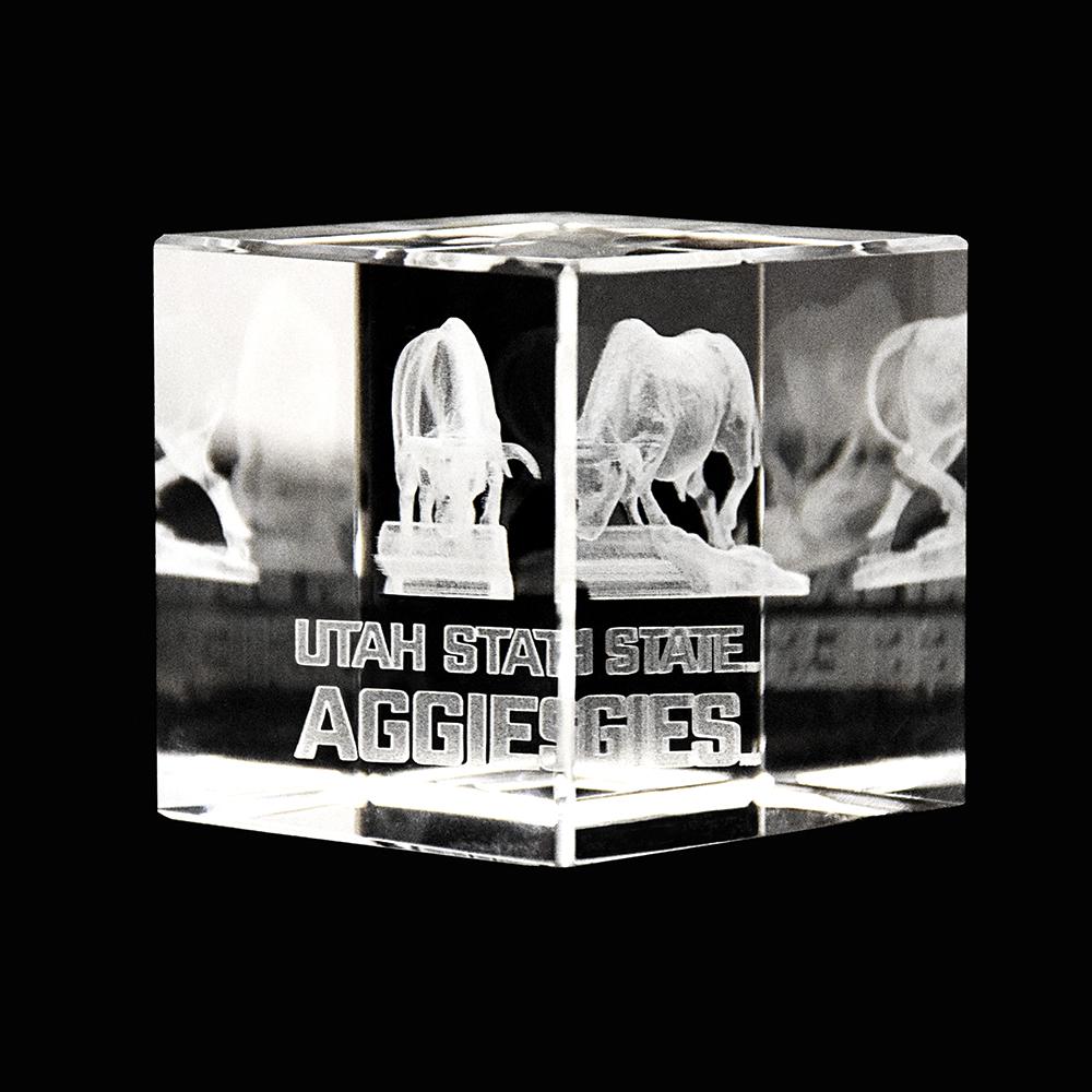 A beautifully crafted Utah State Crystal Cube showcasing the university logo inside a clear optical crystal, reflecting light elegantly.