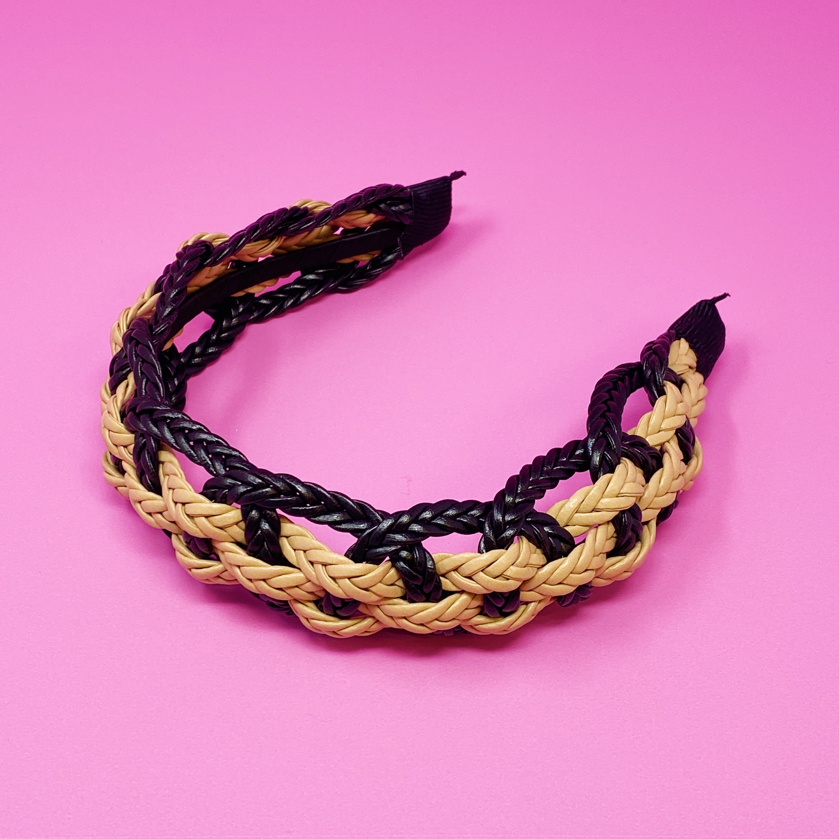 A stylish vegan leather braided headband with soft edges, perfect for enhancing any outfit.