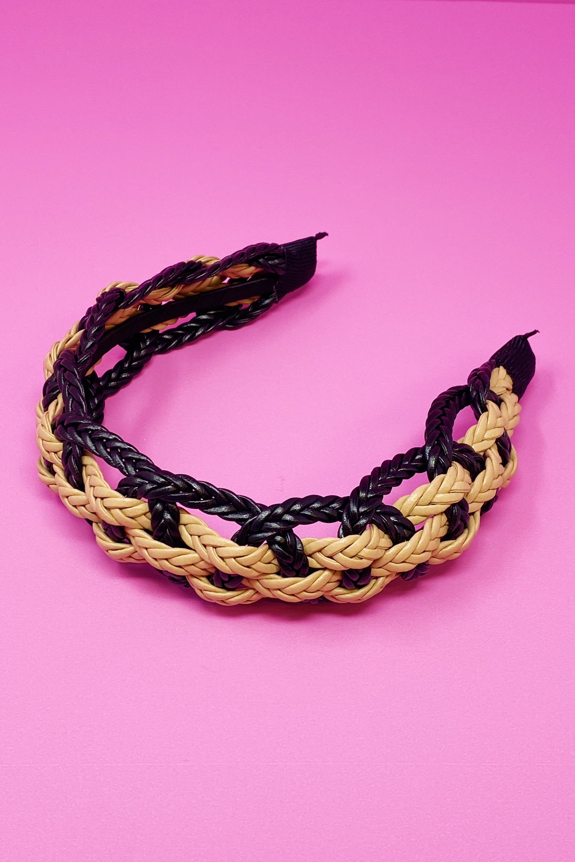 A stylish vegan leather braided headband with soft edges, perfect for enhancing any outfit.