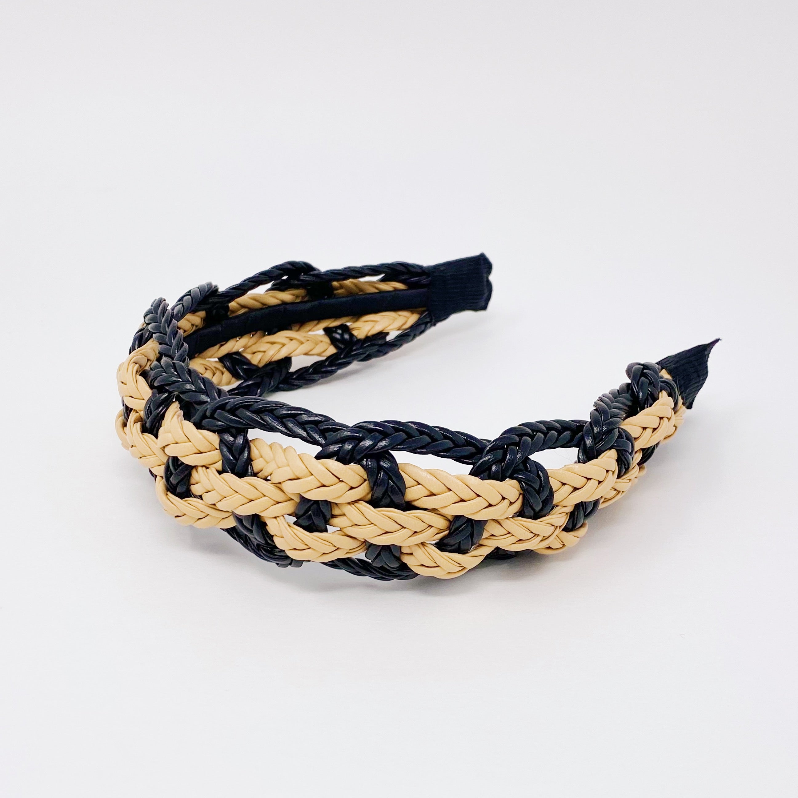 A stylish vegan leather braided headband with soft edges, perfect for enhancing any outfit.