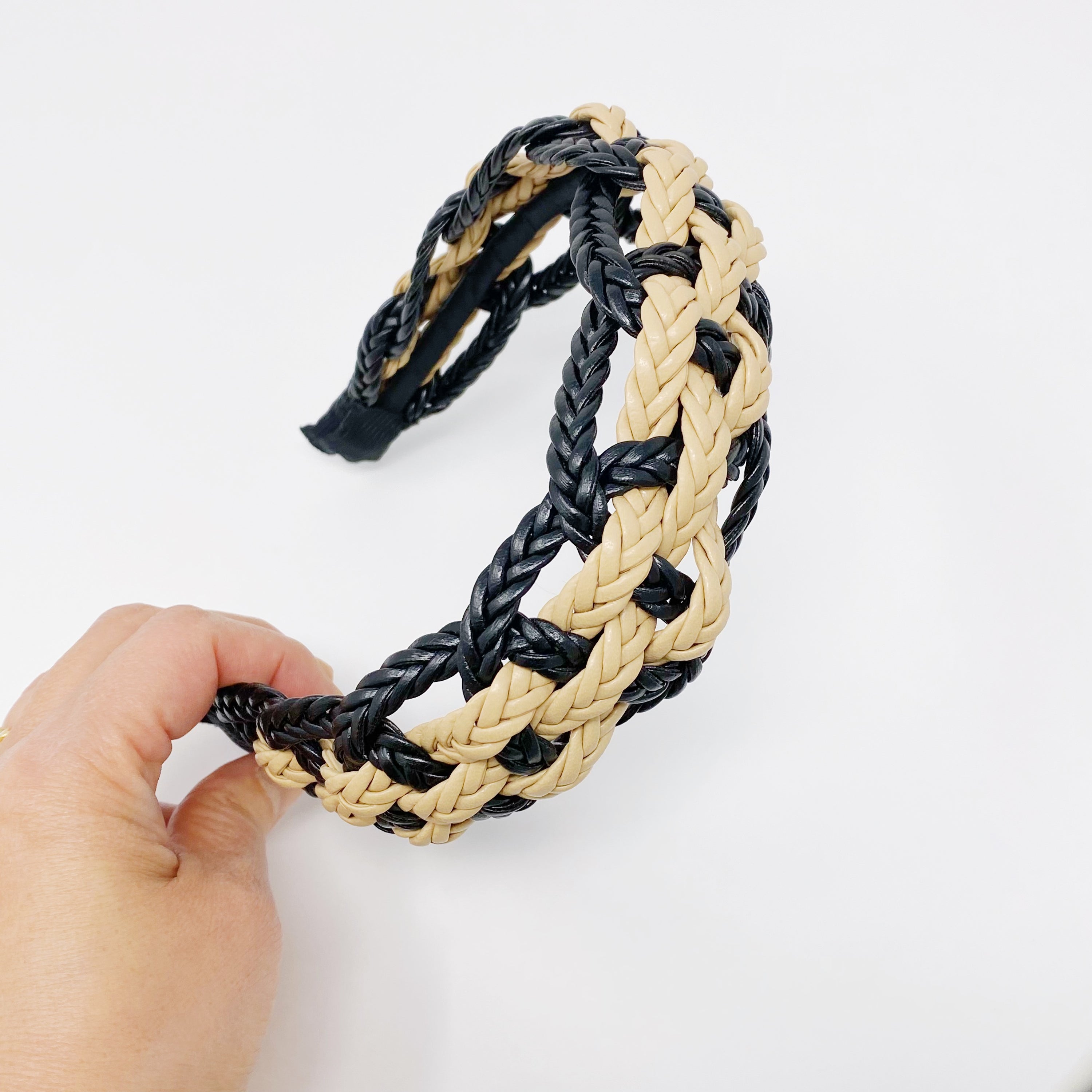 A stylish vegan leather braided headband with soft edges, perfect for enhancing any outfit.