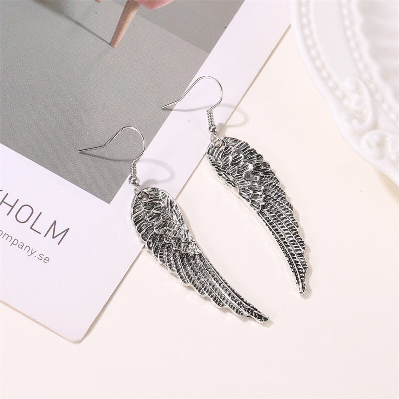 A pair of vintage angle's wing earrings made from alloy, showcasing intricate wing designs.