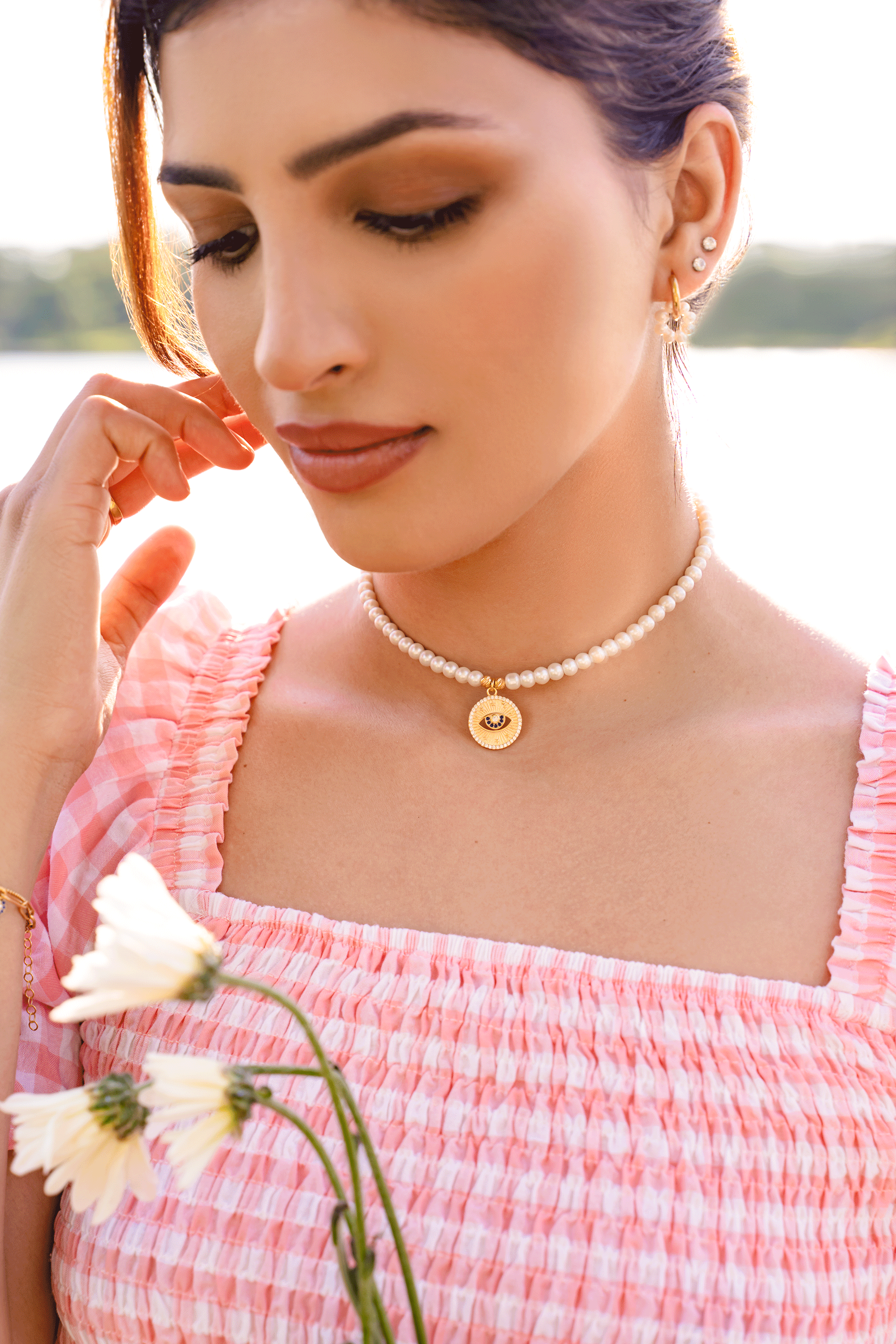 VIOLA Choker featuring white freshwater pearls and a sparkling evil eye talisman pendant, elegantly designed for style and protection.