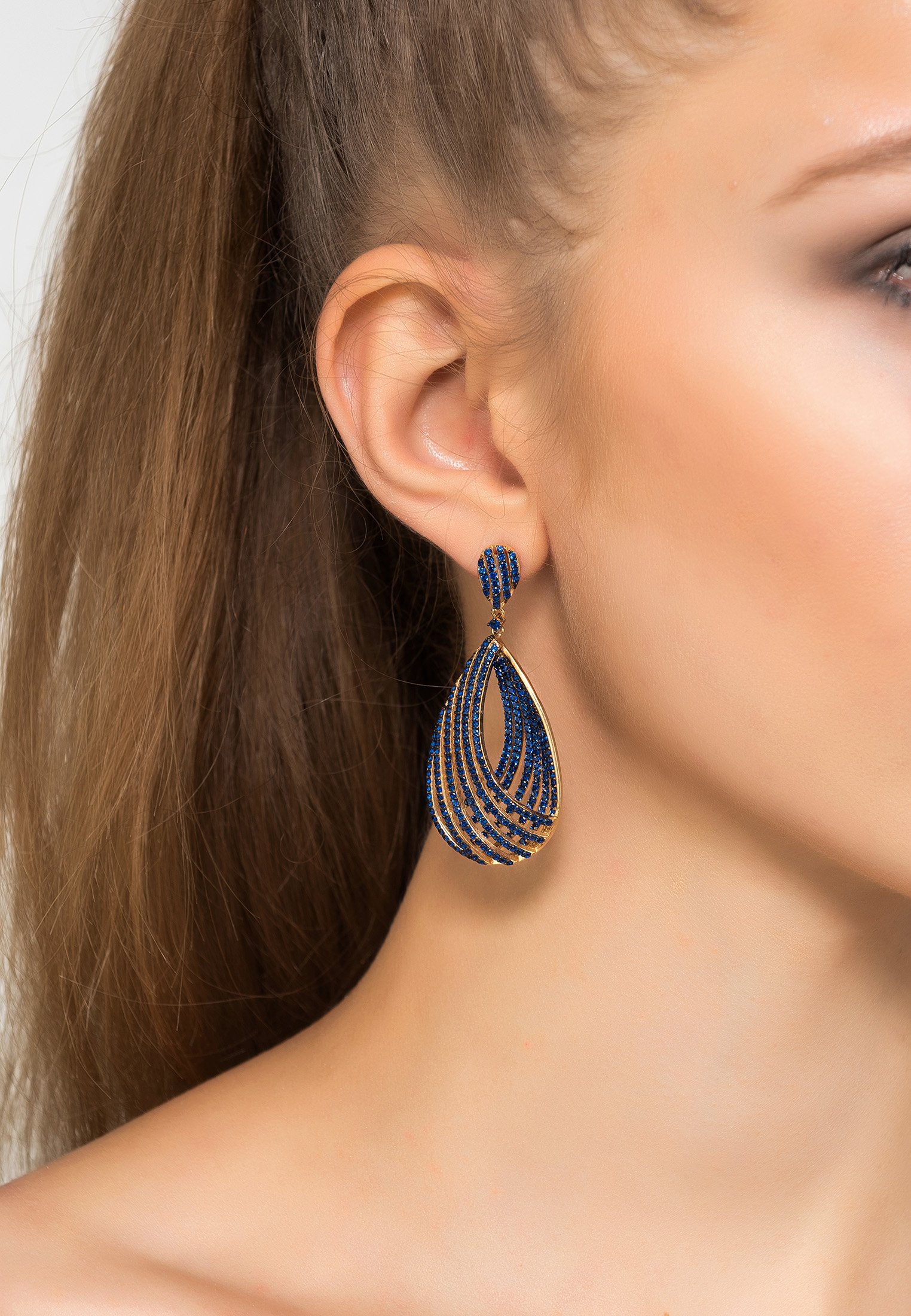 Elegant Vortex Teardrop Earrings in Sapphire Blue Cz Gold, featuring intricate design and sparkling zircon details.