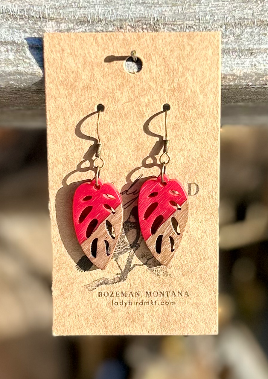 Walnut wood and bright red resin leaf earrings showcasing unique grain patterns and vibrant color.